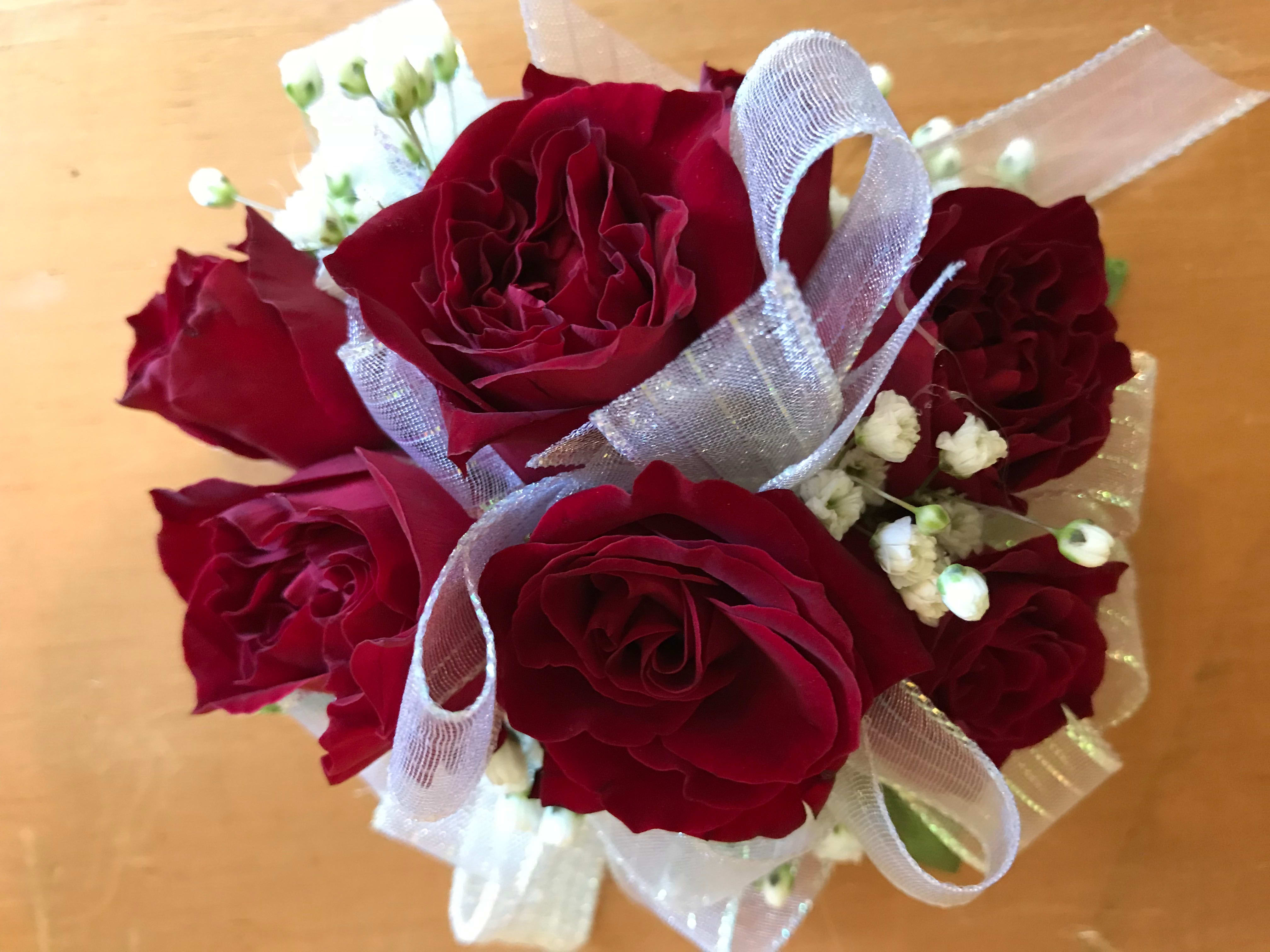 Red Rose Corsage - Red spray roses in a petite wristlet corsage is the perfect compliment to your dress at prom, a wedding or any special occasion. This wristlet can be created in a variety of color roses and ribbons, just let us know what will highlight your dress.