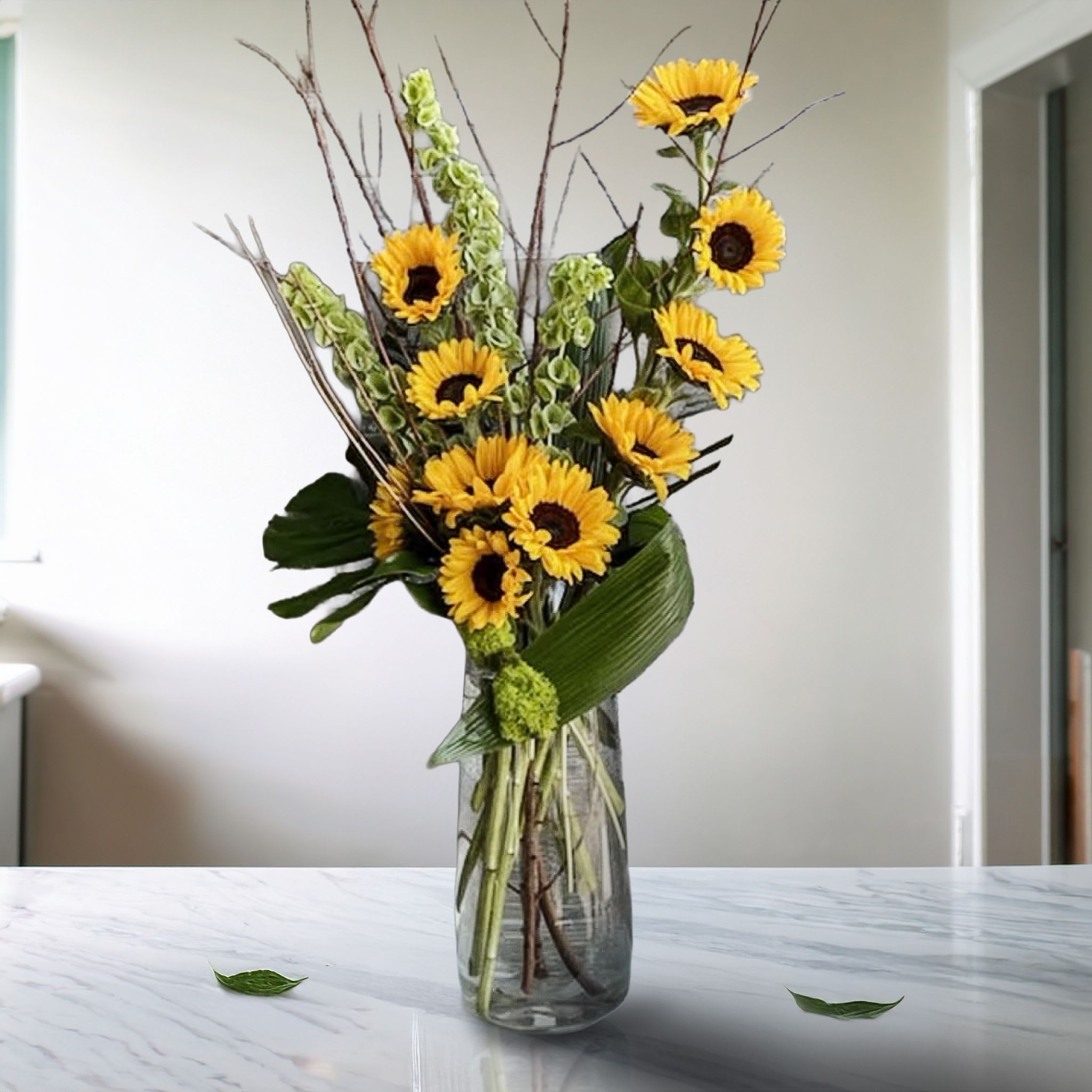 The Funflower Sunflower The Funflower Sunflower - Sunflowers and greens in a contemporary fresh clean display in a clear glass carafe