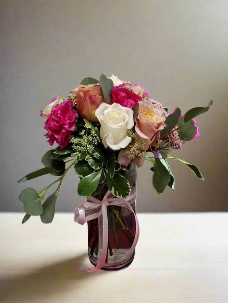 Elegant Harmony Vase Arrangement - Experience the elegance of this stunning vase arrangement, showcasing soft shades of pink, cream, and peach—perfect for a variety of celebrations. This beautiful display features roses, carnations, and either rice flowers or hydrangeas, all enhanced by fragrant eucalyptus greenery.  In our floral creations, we focus on achieving a look that closely aligns with your vision. Each design is distinct and made specifically for you. Given the unique qualities of flowers, some adjustments in color may be needed. Additionally, keep in mind that the prices and availability of seasonal blooms can change.