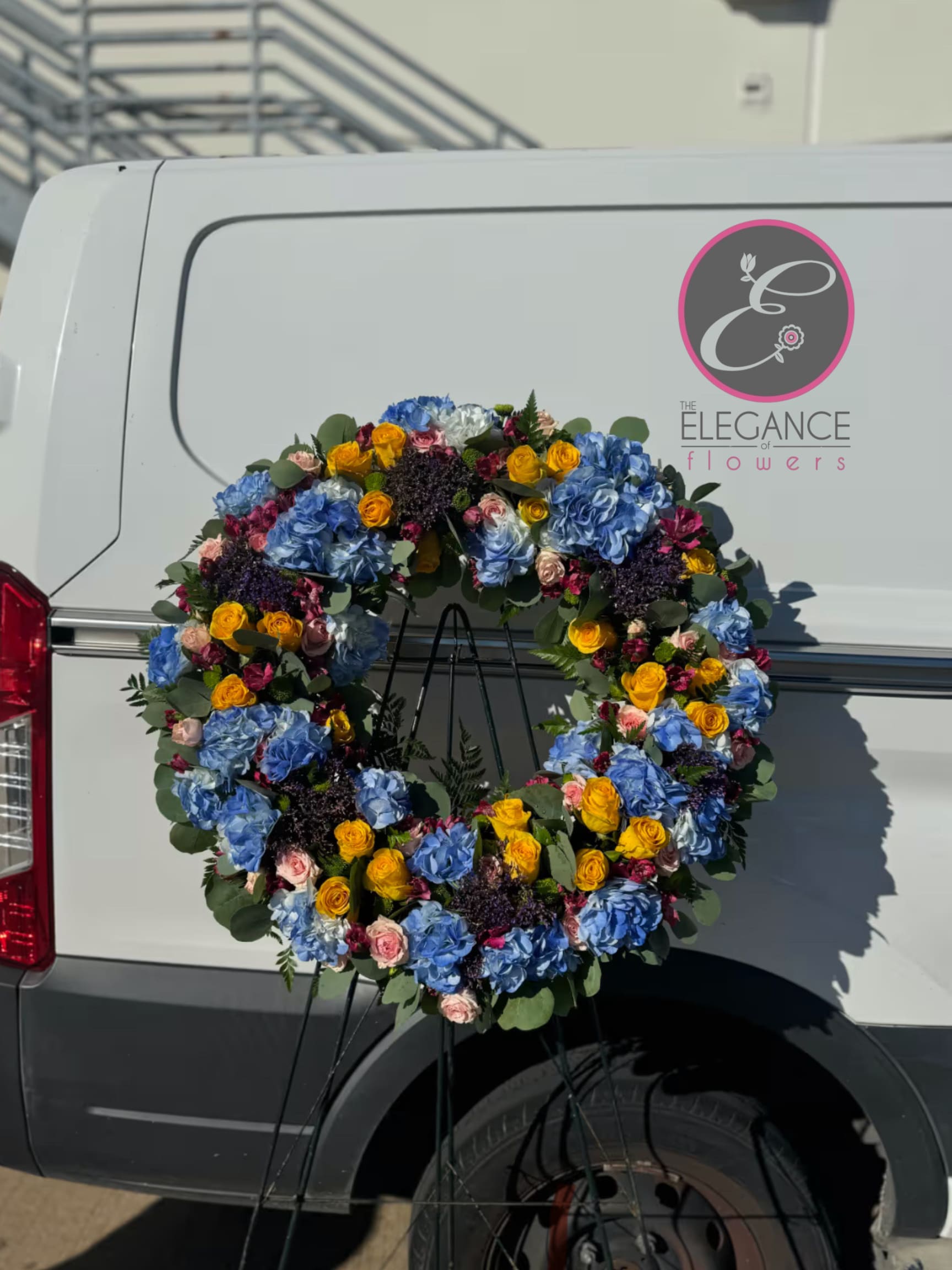 Wreath Stand #2 Wreath Stand #2 - An elegant wreath arrangement crafted with care, symbolizing eternal love, peace, and respect. Perfect for honoring the memory of a cherished loved one and offering comfort during times of loss.