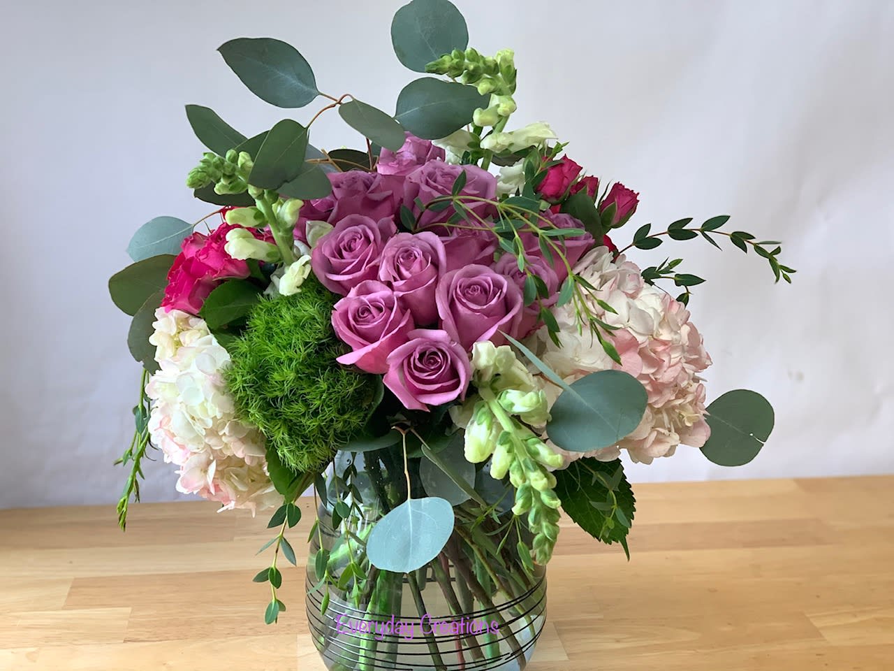 EC34 - Natural Beauty EC34 - Natural Beauty - The Natural Beauty flower arrangement is a stunning mix of lavender roses, green trick dianthus, and snapdragons, all anchored by a bed of fluffy white hydrangeas. The addition of flowing greenery provides an organic and natural look, further enhancing the overall aesthetic appeal. The selection of flowers and greenery create a perfect balance of soft, gentle colors and textures that evoke a sense of calm and tranquility. The particular flower design is perfect for a wide variety of occasions, including weddings, anniversaries, and birthdays. It's also a wonderful way to express sympathy or support during a difficult time, as the natural beauty of the flowers can help to uplift the spirits.