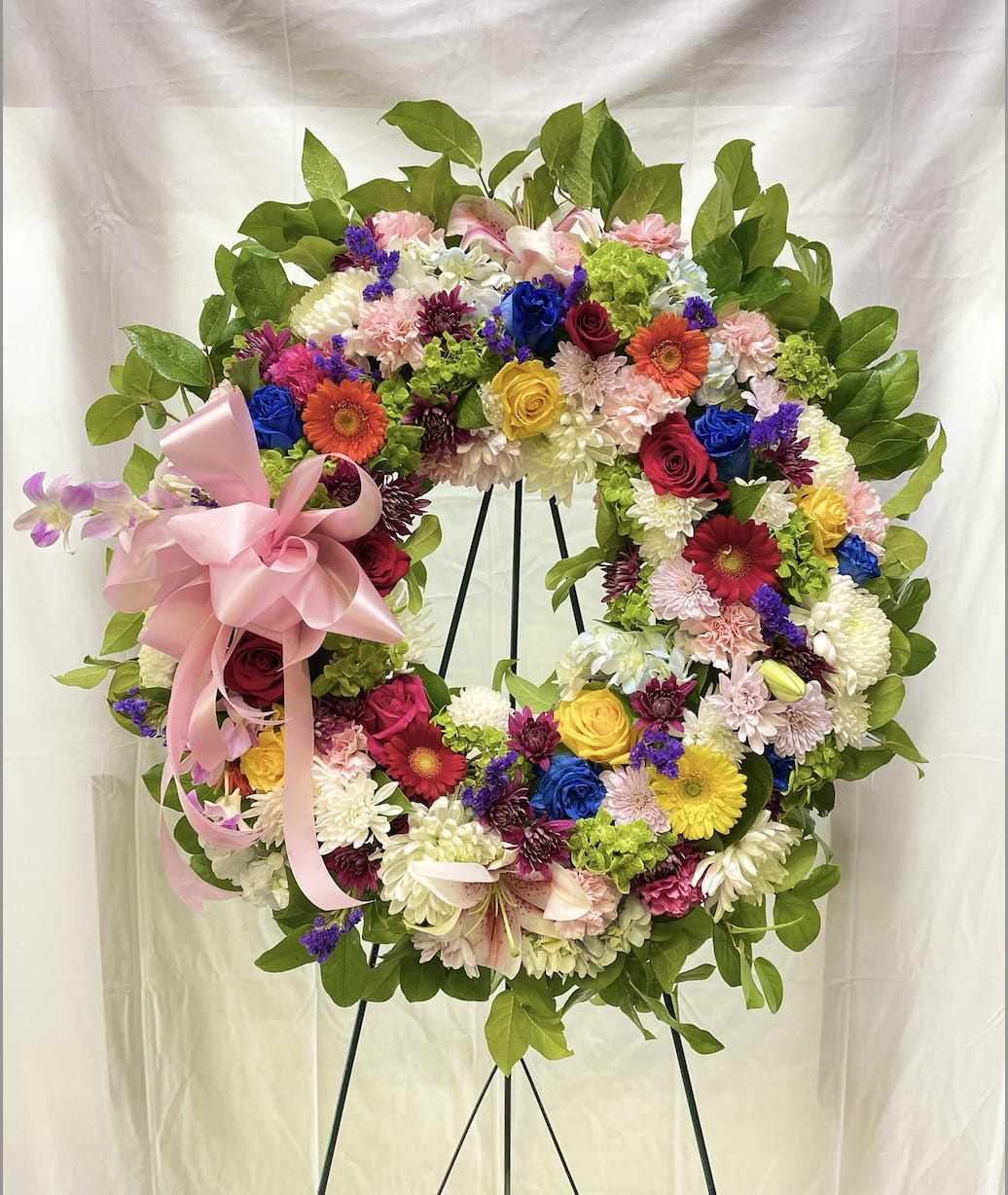 Rainbow Wreath  (Deluxe Shown) - What a way to celebrate life with colors. This wreath is a designer's choice of mixed high-quality florals that suit the look and feel of the pictured arrangement. (picture shown is a deluxe sized wreath, Ribbons interchangeable) 