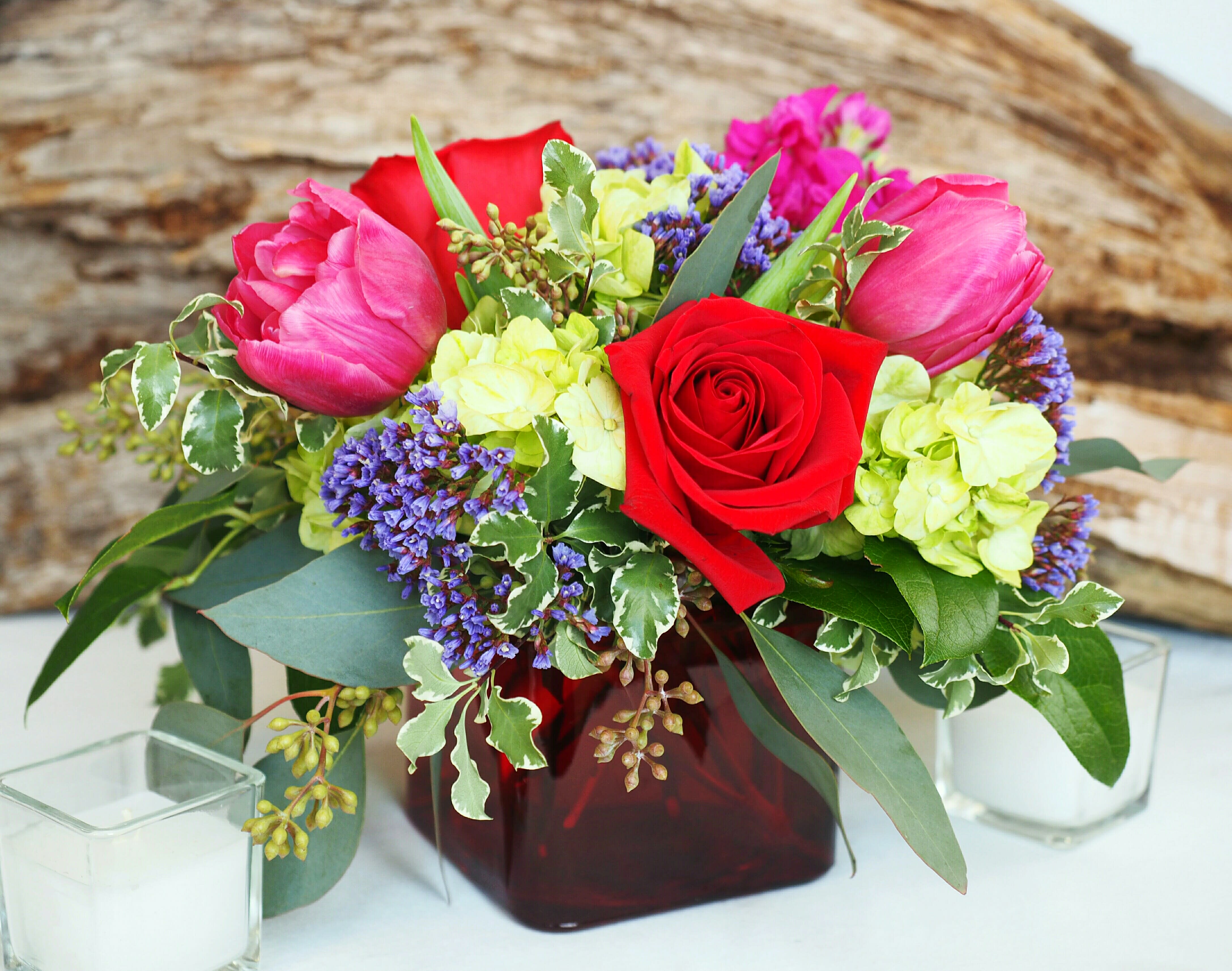 Charlotte  - Vibrant. Fresh. Sophisticated.   Low and full design with fluffy hydrangea, roses, tulips, and mixed greens in an elegant colorful glass cube vase.   *SYMPATHY/FUNERAL: PLEASE NOTE THE TIME, PLACE, &amp; NAME OF THE DECEASED FOR THE SERVICE IN THE SPECIAL NOTES SECTION OF YOUR ORDER - WE ARE UNABLE TO GUARANTEE DELIVERY TIME WITHOUT THIS.*