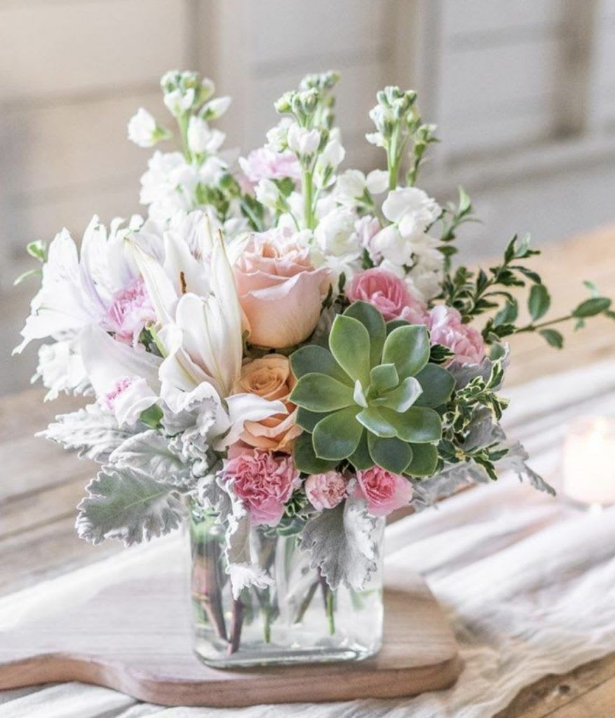 Southern Peach Bouquet - Looking for a modern twist on an old classic - this bouquet is just what you need! The Southern Peach Rose Bouquet brings you a subtle and sophisticated look with a bit of modern style. Charming and easy on the eyes, with beautiful pastel tones, this bouquet brings a room to life with it's artful appearance. Peach roses surrounded by white lilies, peach carnations and greenery - but the best part? All of this surrounds a green echeveria succulent. The fun new accessory to any bouquet, this delicate succulent adds a modern touch and is guaranteed to delight!  This bouquet measures 15 1/4&quot; W by 13 1/4&quot; H