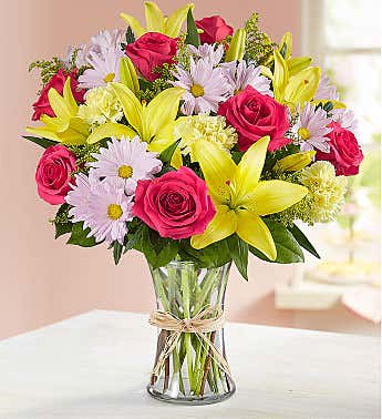 Designer choice flowers   - Designer choice flowers for mother day  pictured is the premium price 4 yellow day lily 7 Hot Pink roses 4,Lavender daisy,  6 Yellow Carnations, yellow solid ago sala in a 8 inch glass vase 