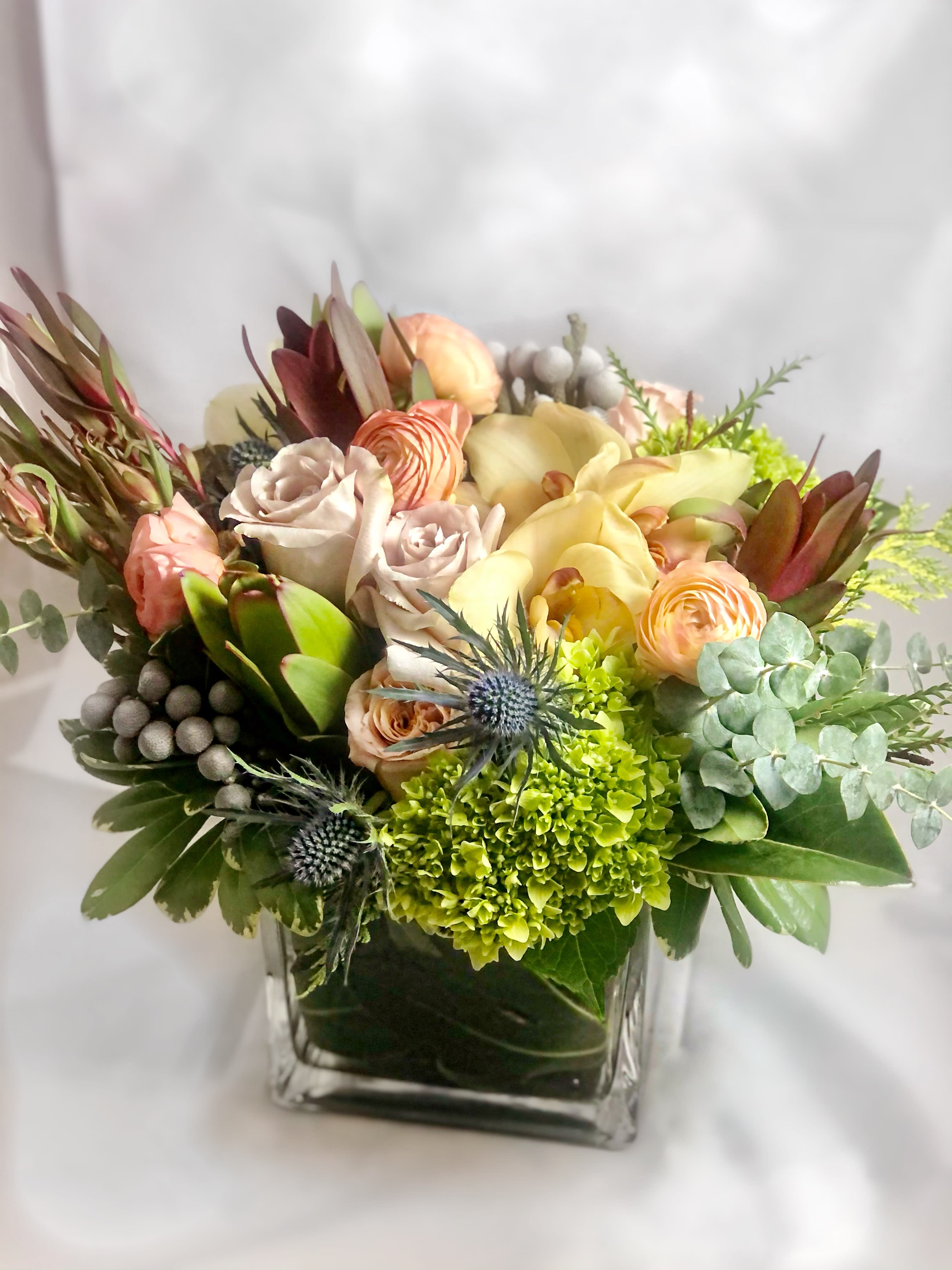 Myriad Medley Myriad Medley - Unique, muted, interesting. This is for the flower aficionado who loves to discover new and interesting shapes, colors and textures. This lovely grouping can include roses, ranunculus, cymbidium orchids, mini green hydrangeas, leucadendron, berzillia berry, baby blue eucalyptus and blue thistle. An art piece in itself! Perfect flowers for birthdays, "get well soon," new baby, sympathy, congratulations, romantic gestures, and "Thank you." Also a beautiful wedding palette. Available for delivery in Seattle, Bellevue, Shoreline, and surrounding areas. Available for delivery in all neighborhoods in Seattle including Magnolia, Ballard, Fremont, Downtown, Queen Anne, Crown Hill, U District, West Seattle, International District, Capitol Hill, Pioneer Square, Beacon Hill, Columbia City, Georgetown, etc.