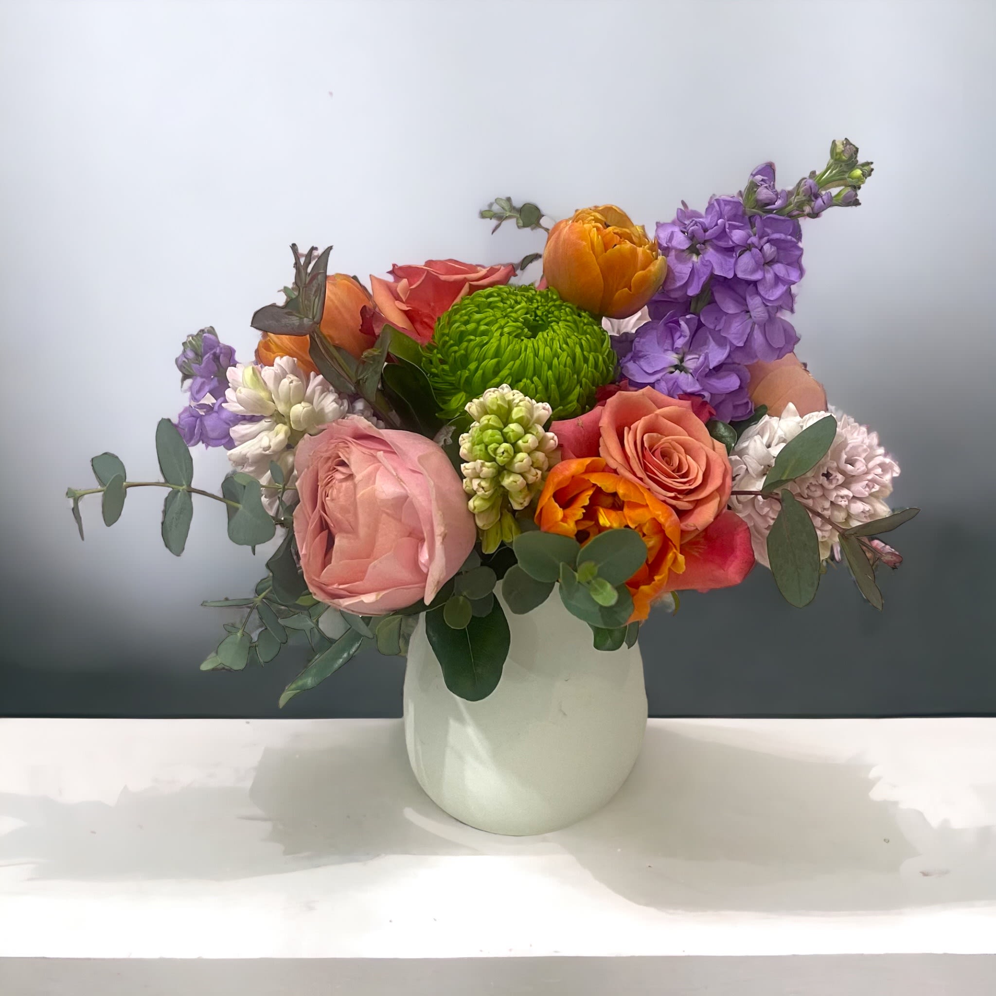 On Broadway On Broadway - Beautiful pastel hues take front and center stage in assorted seasonal blooms in a white ceramic vase. Perfect flowers for birthdays, "get well soon," new baby, sympathy, congratulations, romantic gestures, and "Thank you." Available for delivery in Seattle, Bellevue, Shoreline, and surrounding areas. Available for delivery in all neighborhoods in Seattle including Magnolia, Ballard, Fremont, Downtown, Queen Anne, Crown Hill, U District, West Seattle, International District, Capitol Hill, Pioneer Square, Beacon Hill, Columbia City, Georgetown, etc.