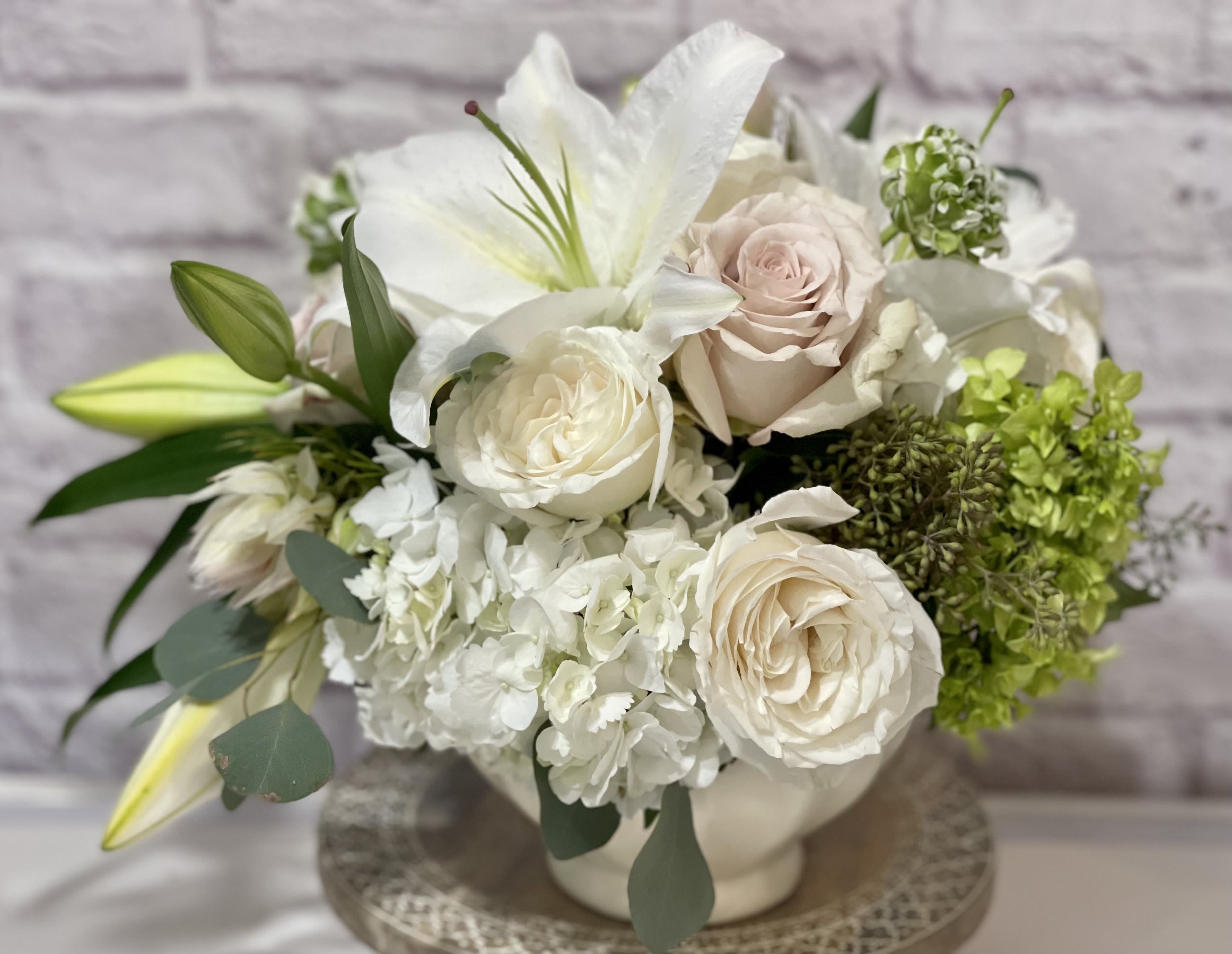 Pure Peace Pure Peace - White and Pearl hues in a white ceramic vase, Featuring lilies, roses and hydrangea. Perfect flowers for birthdays, "get well soon," new baby, sympathy, congratulations, romantic gestures, and "Thank you." Also a beautiful wedding arrangement. Available for delivery in Seattle, Bellevue, Shoreline, and surrounding areas. Available for delivery in all neighborhoods in Seattle including Magnolia, Ballard, Fremont, Downtown, Queen Anne, Crown Hill, U District, West Seattle, International District, Capitol Hill, Pioneer Square, Beacon Hill, Columbia City, Georgetown, etc.
