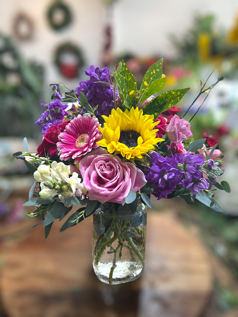 Smile Bouquet  - Bright, colorful, cheerful. A fun mix of seasonal blooms in a recycled glass vase. Featuring stock, sunflowers, gerbera daisies and roses.   Perfect flowers for birthdays, &quot;get well soon,&quot; new baby, sympathy, congratulations, romantic gestures, and &quot;Thank you.&quot; Also a beautiful wedding palette.  Available for delivery in Seattle, Bellevue, Shoreline, and surrounding areas. Available for delivery in all neighborhoods in Seattle including Magnolia, Ballard, Fremont, Downtown, Queen Anne, Crown Hill, U District, West Seattle, International District, Capitol Hill, Pioneer Square, Beacon Hill, Columbia City, Georgetown, etc. 