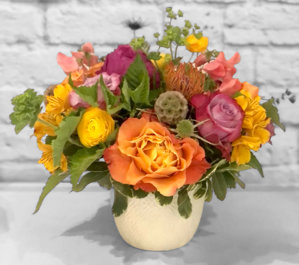Summer Sunsets Summer Sunsets - A warm sunset palette arranged skillfully in a ceramic vase. Featuring yellows, oranges, purples, and peach in roses, ranunculus, protea and more. Perfect flowers for birthdays, "get well soon," congratulations, romantic gestures, and "Thank you." Also a beautiful wedding palette. Available for delivery in Seattle, Bellevue, Shoreline, and surrounding areas. Available for delivery in all neighborhoods in Seattle including Magnolia, Ballard, Fremont, Downtown, Queen Anne, Crown Hill, U District, West Seattle, International District, Capitol Hill, Pioneer Square, Beacon Hill, Columbia City, Georgetown, etc.