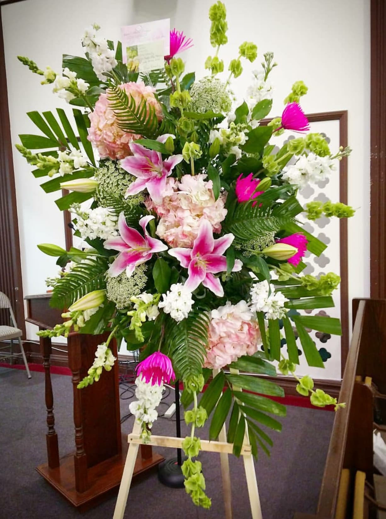 Pink Unique Spray Pink Unique Spray - This style has a uniqueness shape that allows the greens and flowers to flow perfectly. Pink tones of hydrangea, spider mums, lilies, snapdragon, stock, and queen Ann's lace are what create this beautiful look. Upgrade will get roses added.