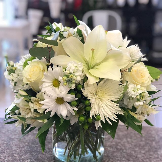 Beautiful in white bouquet Beautiful in white bouquet - This serene arrangement cheers the heart. Is creamy roses and snowy lilies arranged in a cylinder. Includes coffee beans, spider mums, Stock, daisies and alstroemerias.