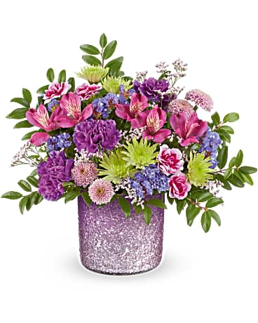 Jewel Garden Bouquet Jewel Garden Bouquet - Win Mom's heart with Teleflora's Radiant Reverie vase, featuring a shimmering purple gradient finish. The perfect keepsake for a dreamy Mother's Day bouquet, it's a timeless centerpiece she'll cherish. Teleflora's Jewel Garden Bouquet features purple alstroemeria, purple carnations, variegated purple miniature carnations, green and lavender button spray chrysanthemums, purple sinuata statice, pink limonium, and huckleberry. Arranged in a textured, shimmering purple gradient vase, it's a stunning gift for any occasion. Approximately 13 1/2" W x 12 1/2" H