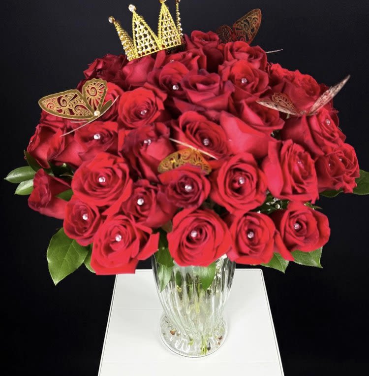 48-Roses Vase Arrangement - The Queen Mother XL Vase Arrangement  When you want to make an unforgettable statement, the Queen Mother XL Vase Arrangement is the way to go. With an awe-inspiring 48 rich, red roses, this breathtaking bouquet is designed to impress, to captivate, and to take someone’s breath away. Every rose is meticulously arranged, accented with soft baby’s breath, and enhanced with shimmering gold metallic butterflies and sparkling diamond-shaped stones that add an extra layer of elegance and sparkle.  Presented in an elegant, oversized glass vase, this massive arrangement is not just a gift—it’s an experience. The vase itself is a stunning, XL base that adds a sense of grandeur, ensuring that the recipient feels nothing short of royalty. To top it off, this arrangement comes with a gorgeous crown placed atop, a symbolic finishing touch that the recipient can keep and cherish forever.  With 48 roses, this arrangement is bold, lavish, and overflowing with beauty—more flowers, more love, and more of the wow factor. It’s perfect for those monumental moments when you want to yell, &quot;I love you&quot; in the most dramatic, romantic way possible. The Queen Mother XL Vase Arrangement is meant to impress, to wow, and to leave the recipient in absolute awe. A luxurious ribbon ties it all together.  It also comes with a small message card from the sender, allowing you to personalize your gesture with a heartfelt note.