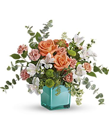 Sunset Splash Bouquet - Inspired by the warm peach skies and crystal blue waters of a tropical sunset, this fun-filled rose bouquet adds a splash of happiness to any occasion!  This delightful arrangement features peach roses, white alstroemeria, peach miniature carnations, green button spray chrysanthemums, spiral eucalyptus, seeded eucalyptus, oregonia, and lemon leaf. Delivered in an Aqua Color Splash Cube. Approximately 16 1/2&quot; W x 13 1/2&quot; H 