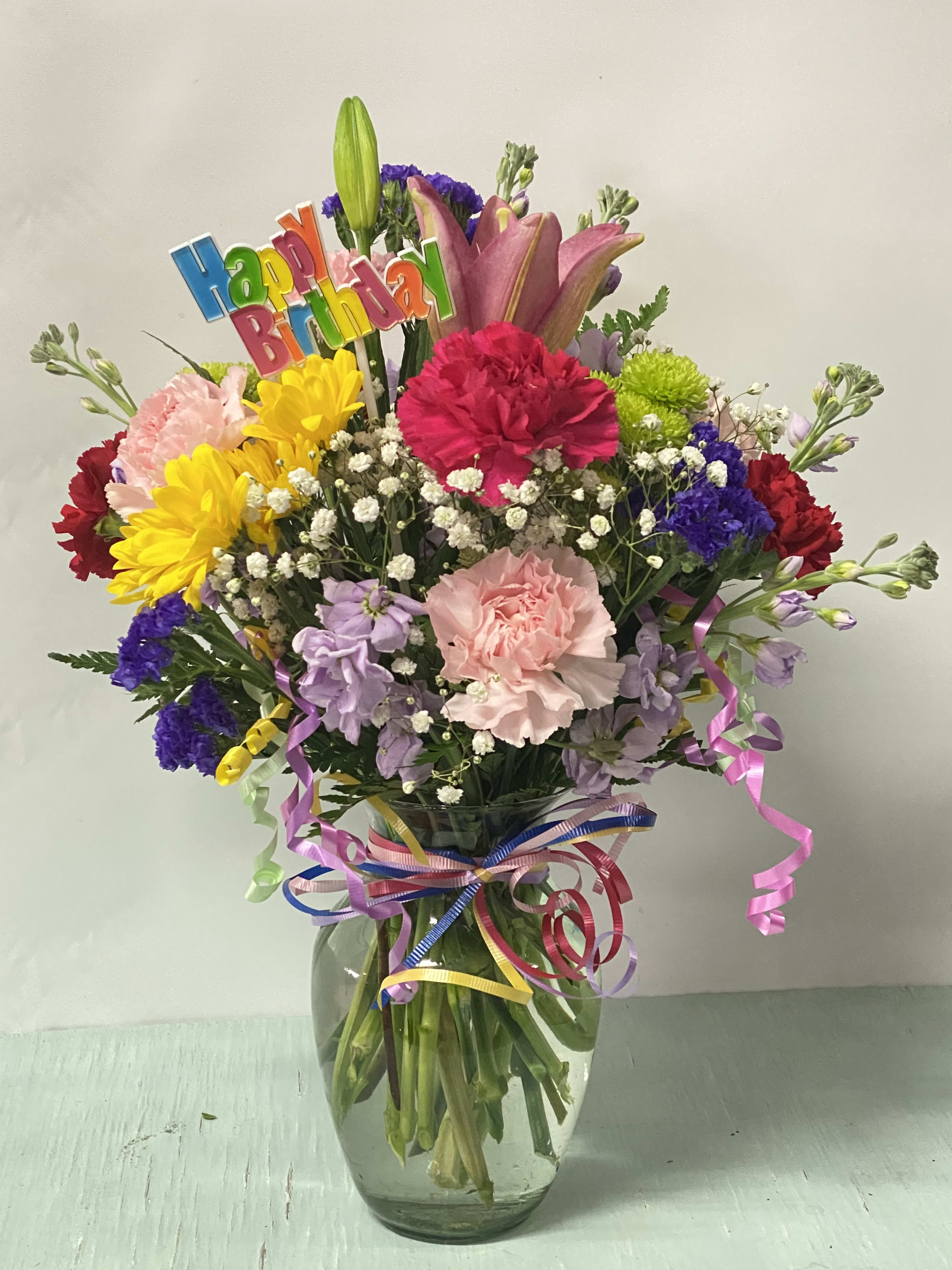 Birthday #2 Birthday #2 - An arrangement of fresh cut flowers designed in a glass vase. Arrangement includes a "happy birthday" Pick. Colors can be modified depending on availability.