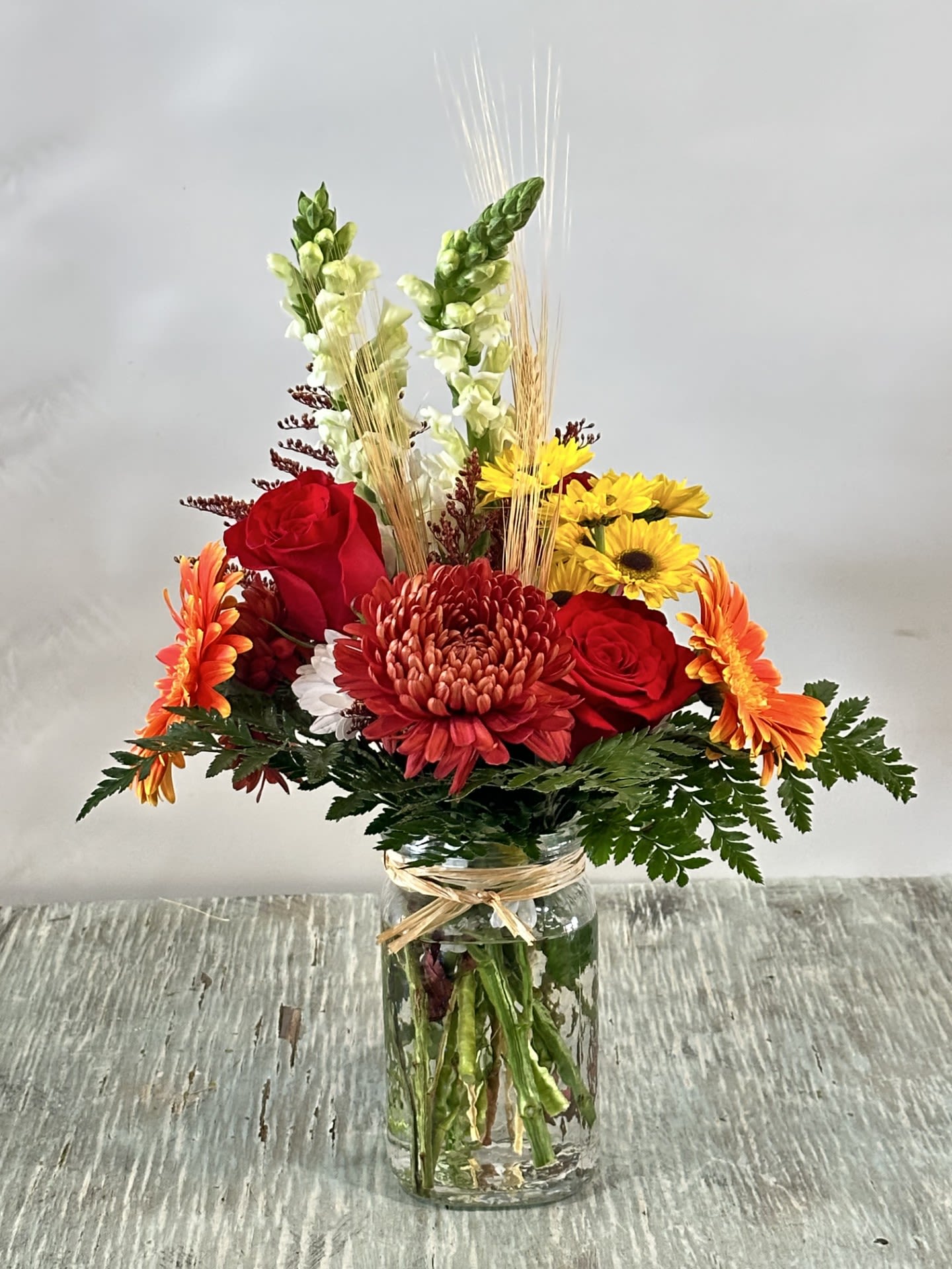 Birthday #3 Birthday #3 - Fall themed arrangement designed in a mason jar like container. Arrangement to include assorted flowers as seen in picture. Flowers are subject to be substituted in case of out of stock product. Flower colors may be modified depending on availability.