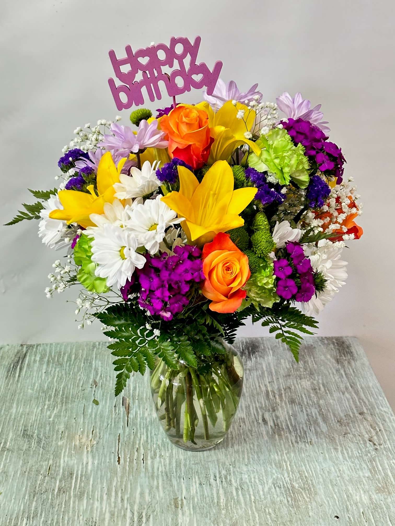 Birthday #4 - Arrangement of mixed flowers. Colorful and cheerful, includes &quot;happy birthday&quot; pick. Please specify under &quot;Florists Instructions&quot; upon checkout the color you would like for the &quot;Happy Birthday&quot; pick. If not selected, pick will be selected at random. Flower colors can be modified depending on availability.
