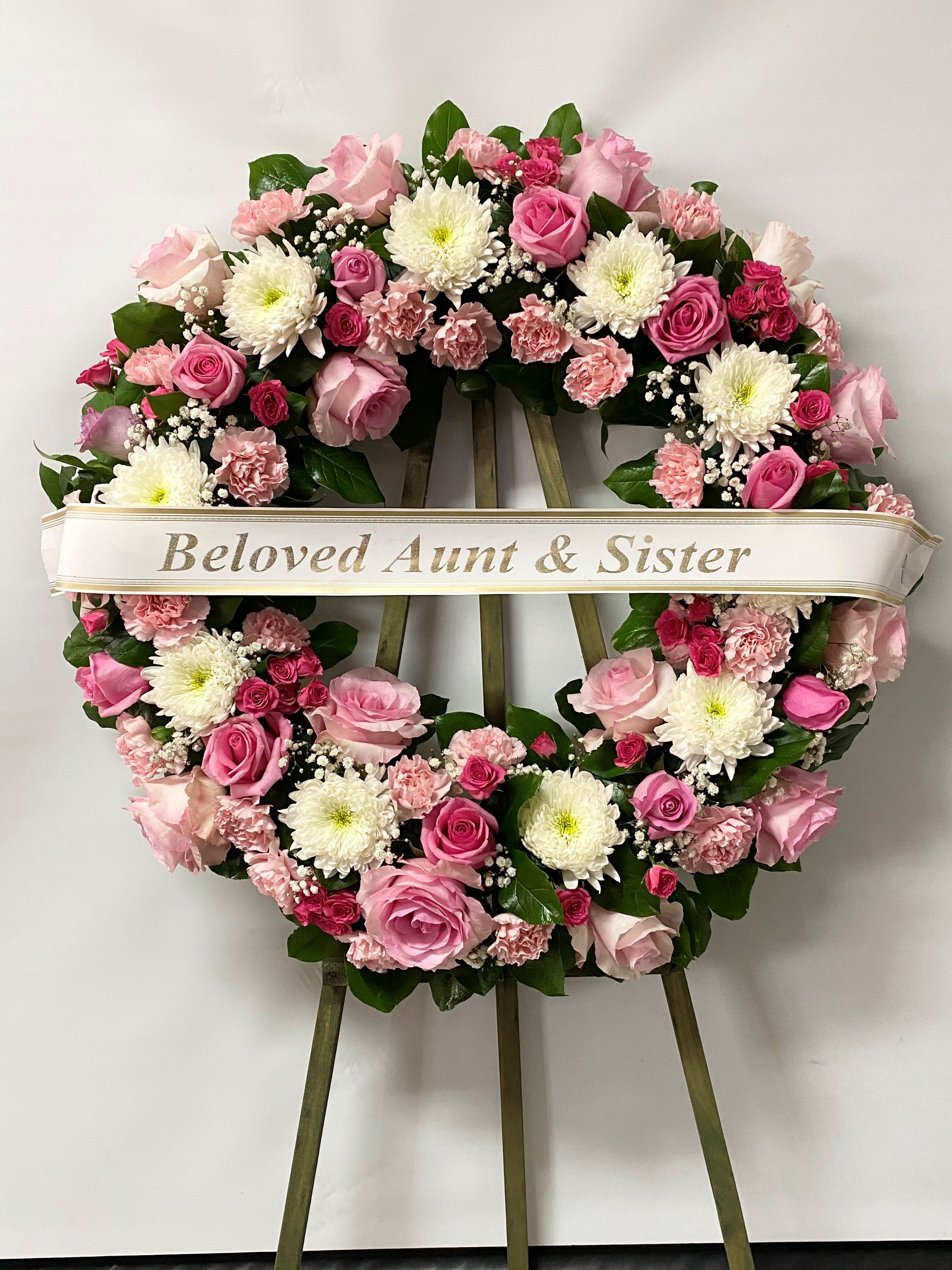 Sympathy Wreath #47 - Standing wreath made of pink and white fresh cut flowers. Colors can be modified depending on availability. Designed on an easel that is included with the arrangement and does NOT need to be returned. Banner is included with arrangement. Please specify what is to be printed on banner upon check out under &quot;FLORIST INSTRUCTIONS&quot;. LIMITED TO 5 WORDS ON BANNER.