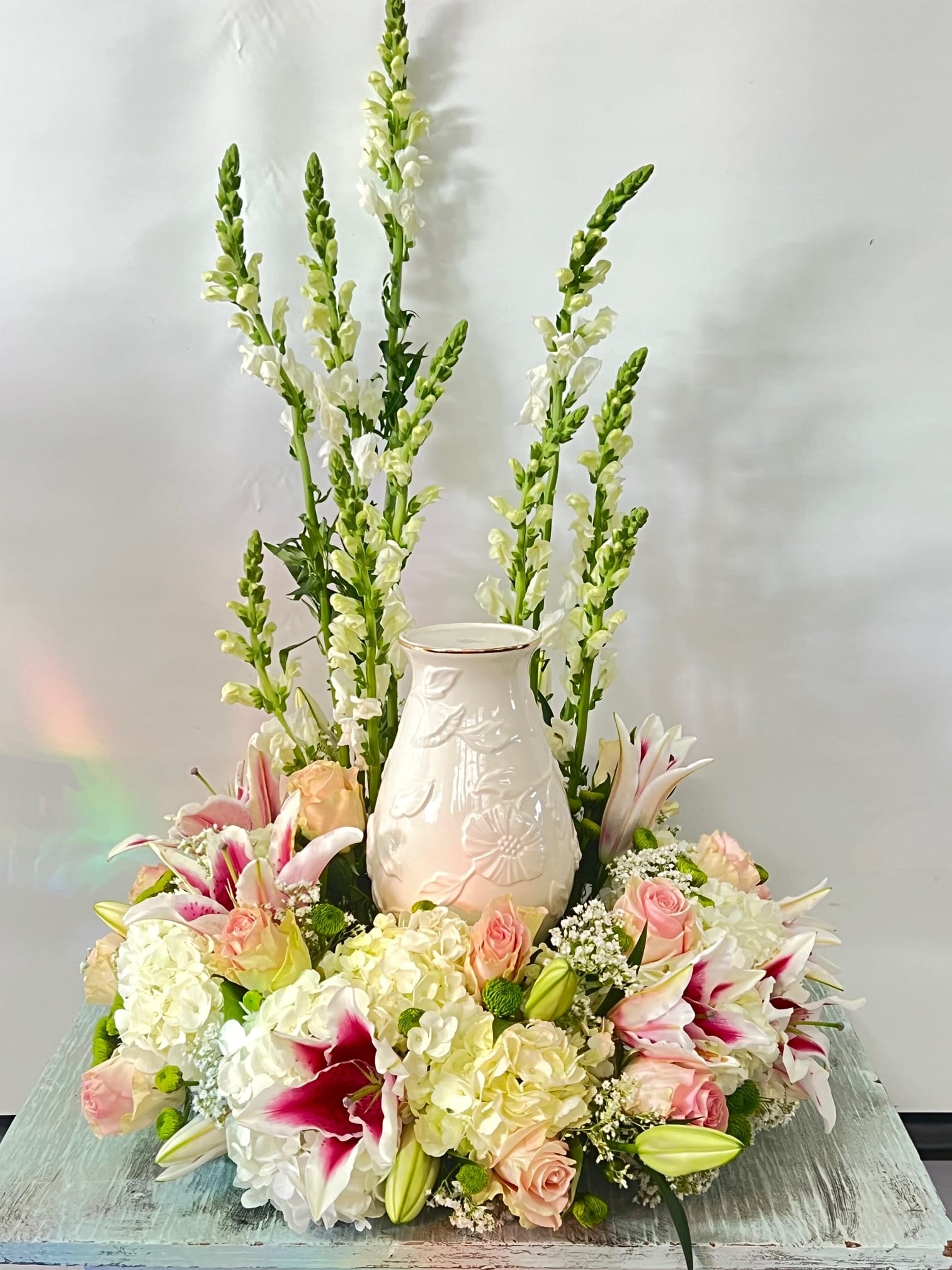 Sympathy Urn Arrangement #31 Sympathy Urn Arrangement #31 - Cremation arrangement. Vase not included only used as an example as to where urn will be placed. Arrangement designed in white and pink colors. Colors can be modified depending on availability.