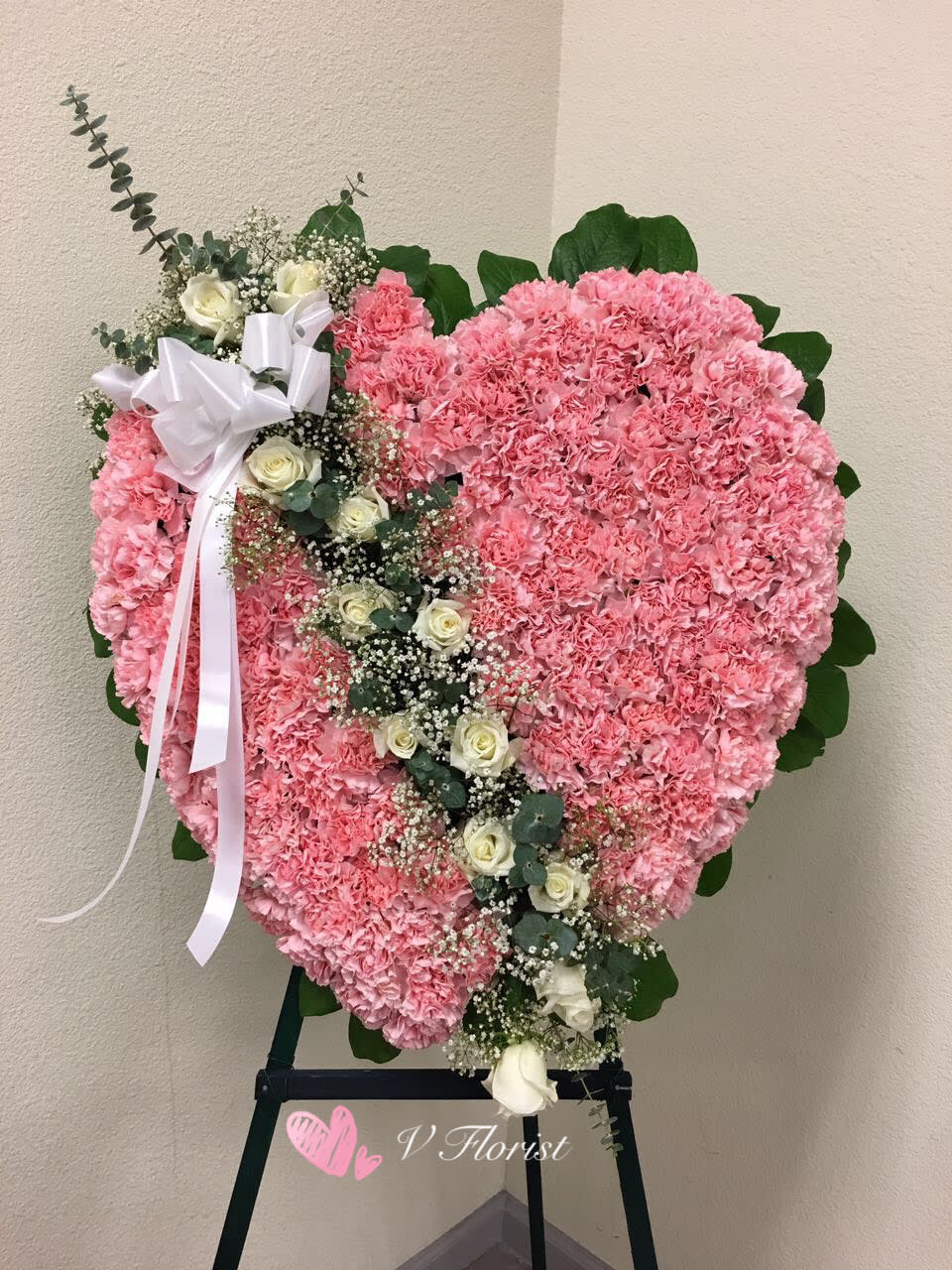 Broken Heart Sympathy Spray A2 Broken Heart Sympathy Spray A2 - The modern funeral spray handcrafted by an artisan florist to deliver your condolences, is constructed of light pink carnations and white rose, complemented by lush greens. It makes a superb, time-honored addition when displayed on a wooden easel for a wake or funeral service, graveside at a burial, to decorate a headstone or to set adrift for burials at sea. Our florists hand-design each arrangement, so colors and assortment may vary based on local availability Orders must be placed three days in advance to allow for processing