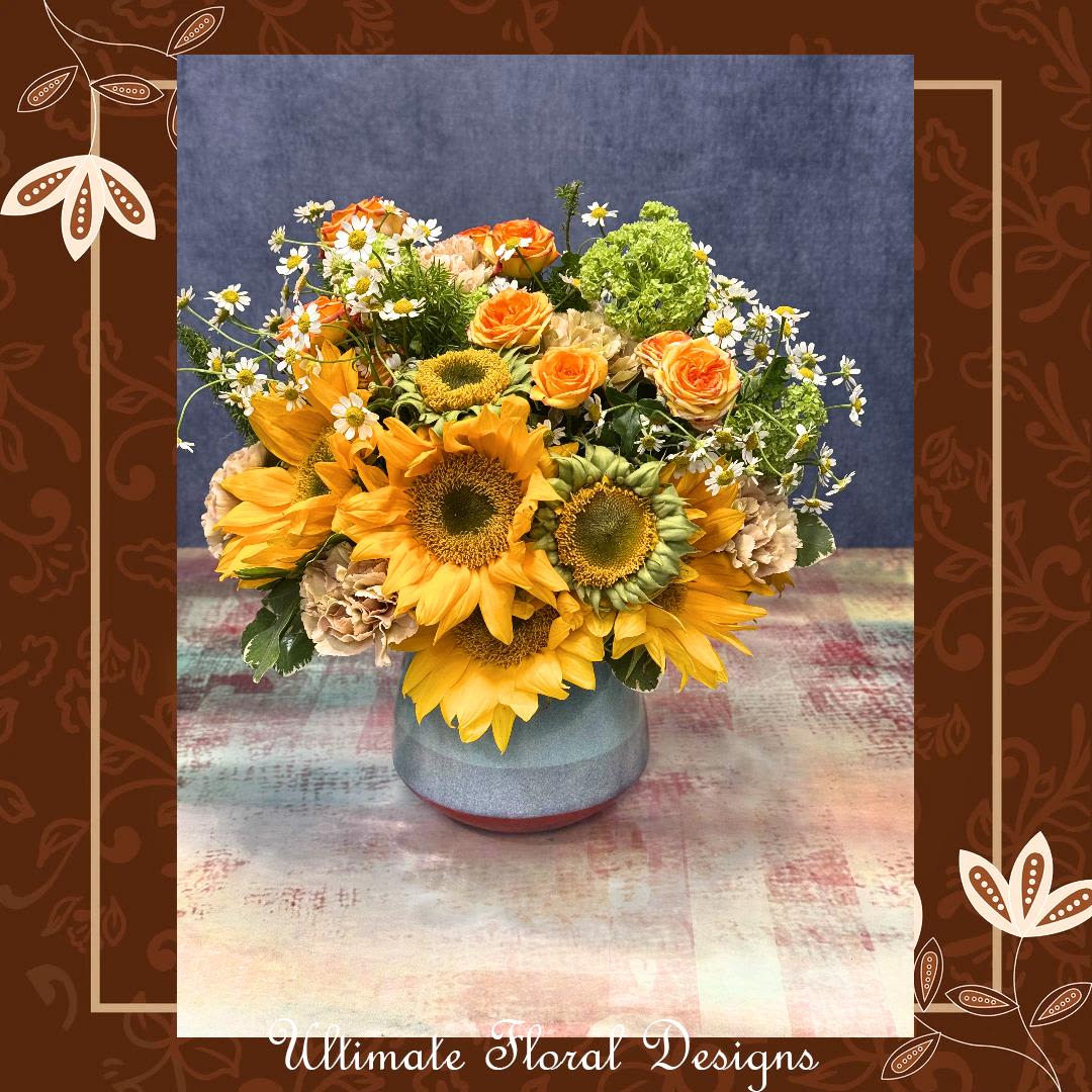 Golden Glow Garden - Brighten someone’s day with Golden Glow Garden, a radiant arrangement handcrafted by your trusted local florist in Great Falls, VA. Featuring cheerful sunflowers, orange spray roses, chamomile, and lush greenery, this design is perfect for birthdays, thank you gifts, or just because.   Designed with care by Ultimate Floral Designs – your go-to florist in the DMV area, serving Northern Virginia, Washington D.C., and Maryland.  Same-day local flower delivery available.  Call (703) 759-5001 or order online at UltimateFloralDesigns.com
