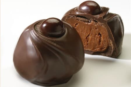 Espresso Cafe Truffle - Ground coffee beans and dark espresso cafe-flavored center, dipped in milk chocolate, then in dark chocolate and topped with a chocolate-covered espresso bean.