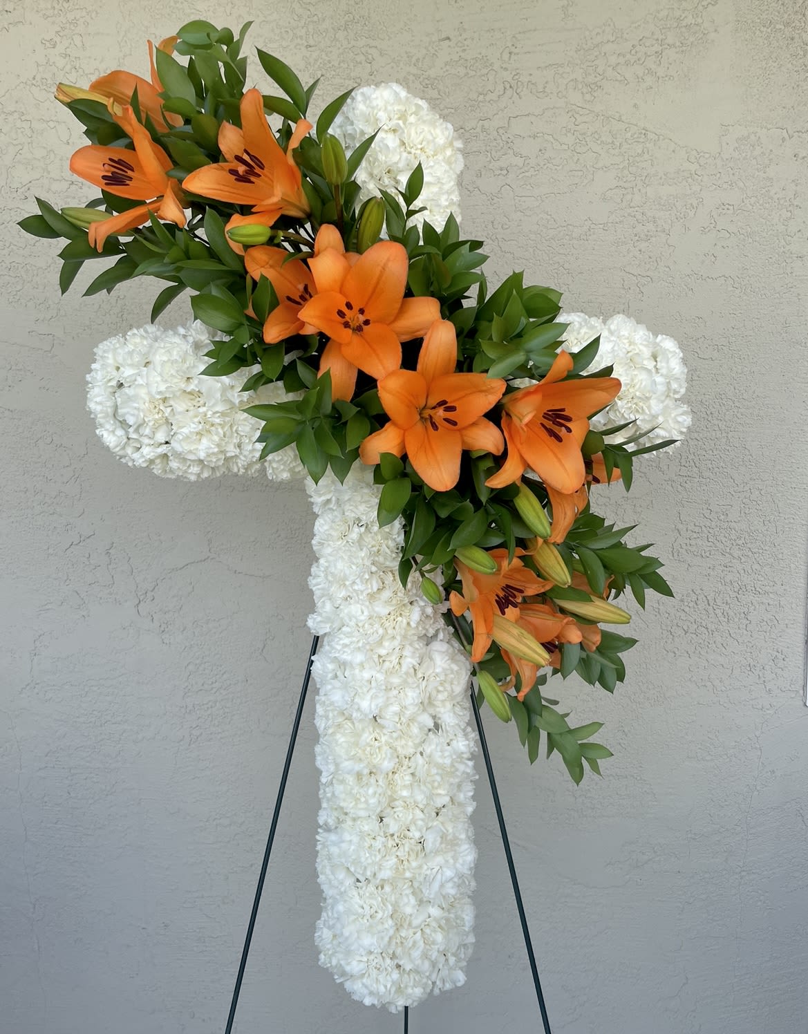 Forever in our hearts Lilies cross - Offer this arrangement in variety of colors Lillies: Pink, White, Yellow, Orange Cross: Roses and Carnations available in most colors 
