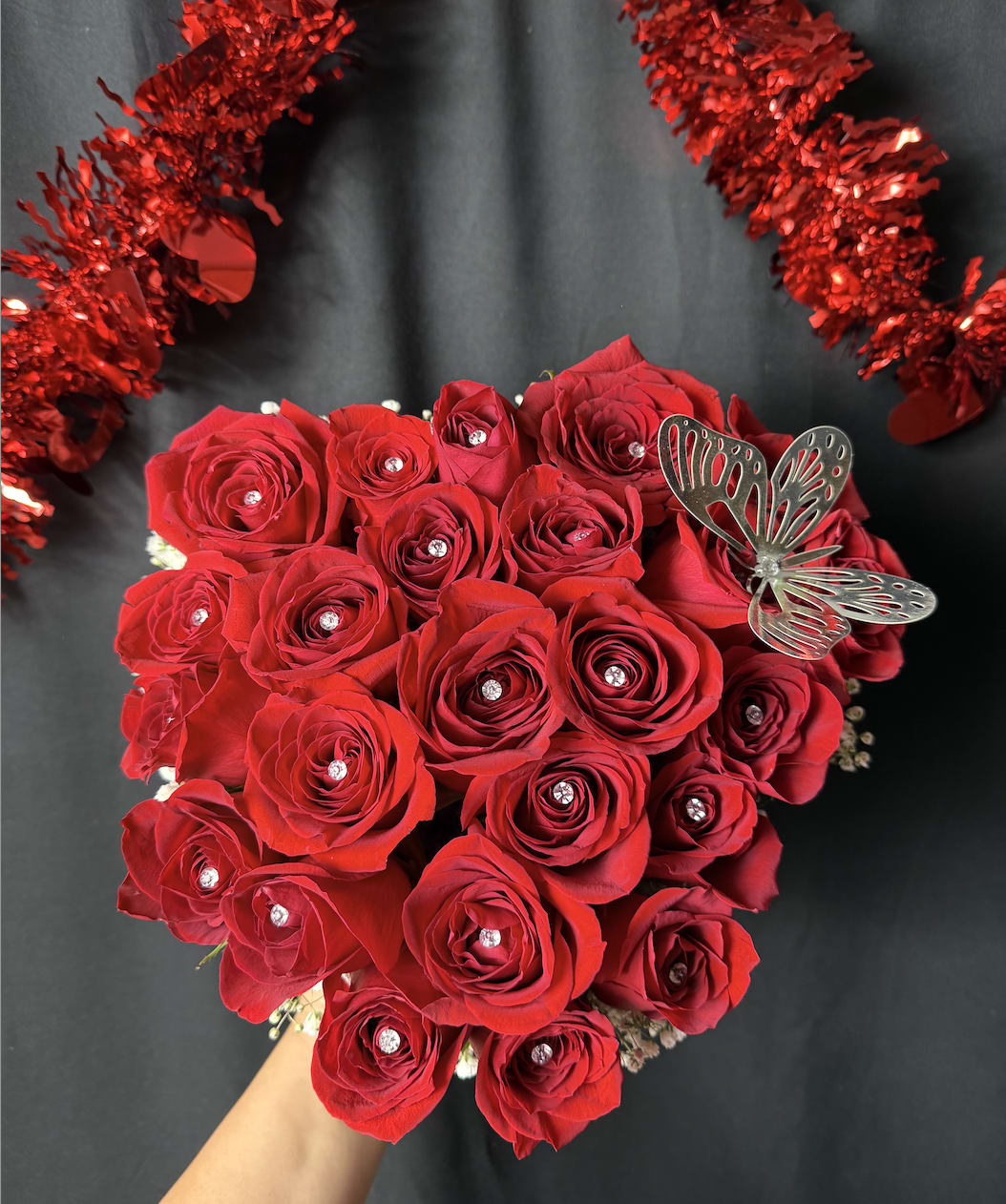 Exclusive Heart-Shaped Red Roses Arrangement Exclusive Heart-Shaped Red Roses Arrangement - Our Exclusive Heart-Shaped Red Roses Arrangement is the perfect expression of love and elegance. This stunning arrangement features over 30 vibrant, deep red roses carefully arranged in a heart-shaped box, designed to captivate the heart of anyone who receives it. To add a touch of sophistication, we've included a delicate metallic butterfly and an elegant ribbon, making this piece not only a gift but a symbol of beauty and grace. Whether for a special anniversary, a heartfelt gesture, or a memorable occasion, this arrangement embodies love, passion, and thoughtfulness. The combination of rich red roses, the charming butterfly, and the luxurious ribbon ensures that this gift will leave a lasting impression. Exclusive. Elegant. Meaningful. A true masterpiece for those who appreciate the finer things in life.