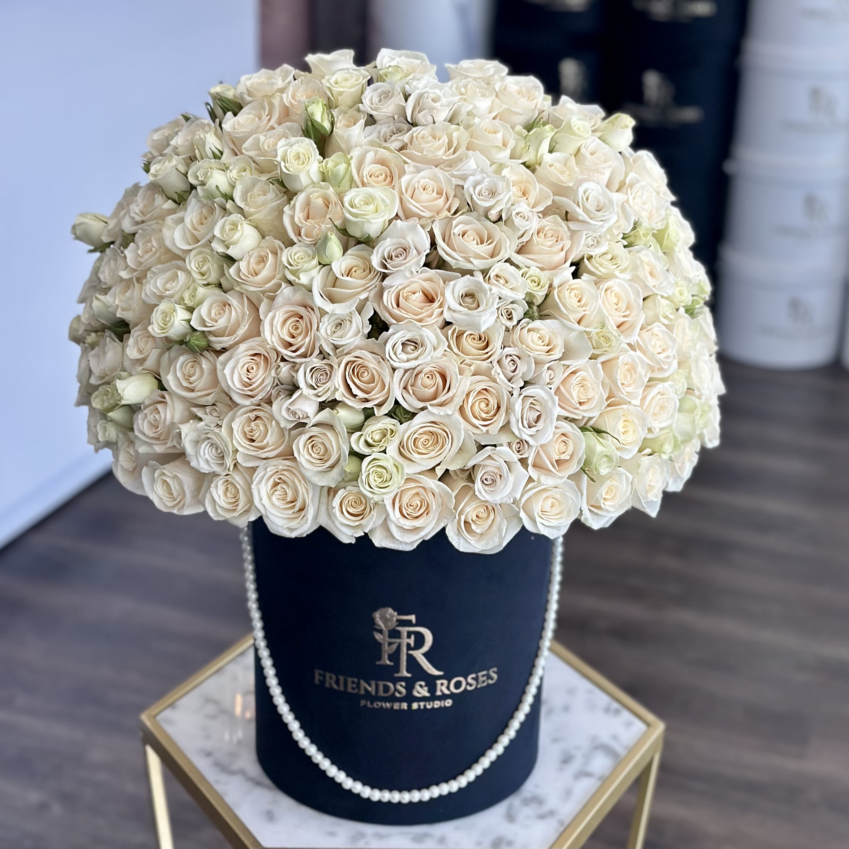 Mona - A graceful arrangement of white roses is presented in our signature box, elegantly adorned with delicate pearls. The soft blooms and pearl-accented box create a timeless and refined composition, perfect for conveying purity, love, and elegance.