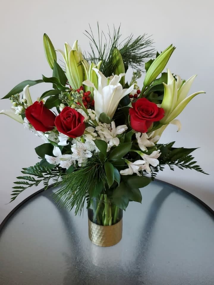 Golden Holiday - Beautiful floral arrangement in a cylinder with a gold ribbon composed of red roses, lilies and alstroemerias