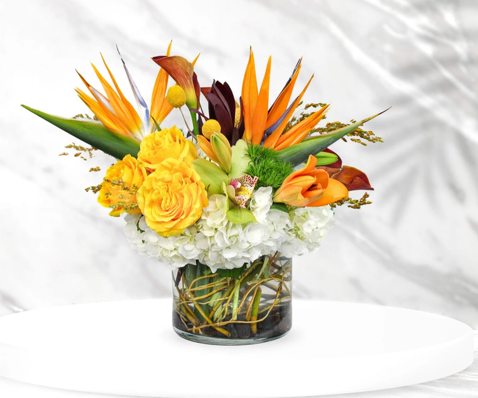 Tropics &amp; Hydrangea - This exquisite arrangement is designed with hydrangea, roses, birds of paradise, lilies, cymbidium orchids, calla lilies, dianthus green trick, crespedia, and safari sunset. 