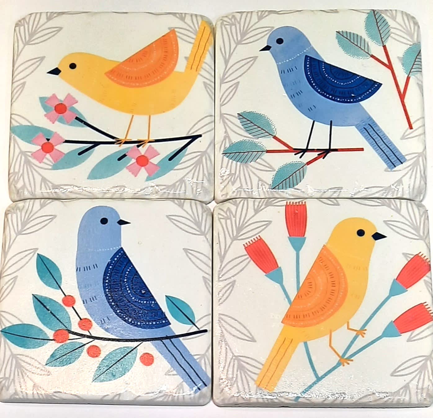 Creative Coasters-Colorful Birds - These colorful birds perch on pretty branches. A perfect gift for yourself or another, this four piece coaster set is made out of resin and has scratch-preventive cork on the bottoms! The coasters measure 4 inches by 4 inches. Please note some of the sets come in a box and others have been hand-tied with a ribbon bow.