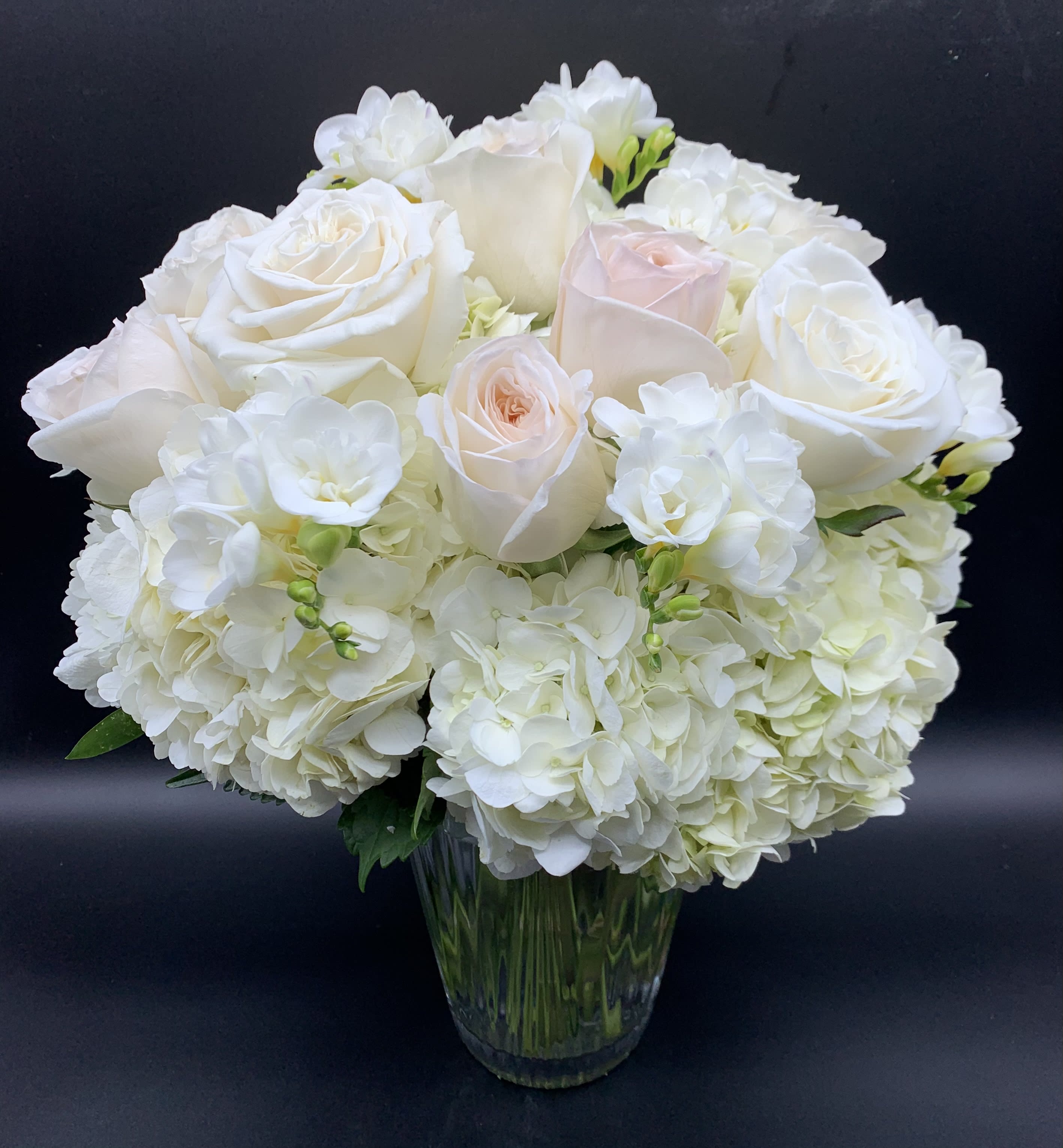 Jeanne - Jeanne is designed with our finest high end white and blush rose, white hydrangea and freesia. Our upgrades add additional fresh blooms. 