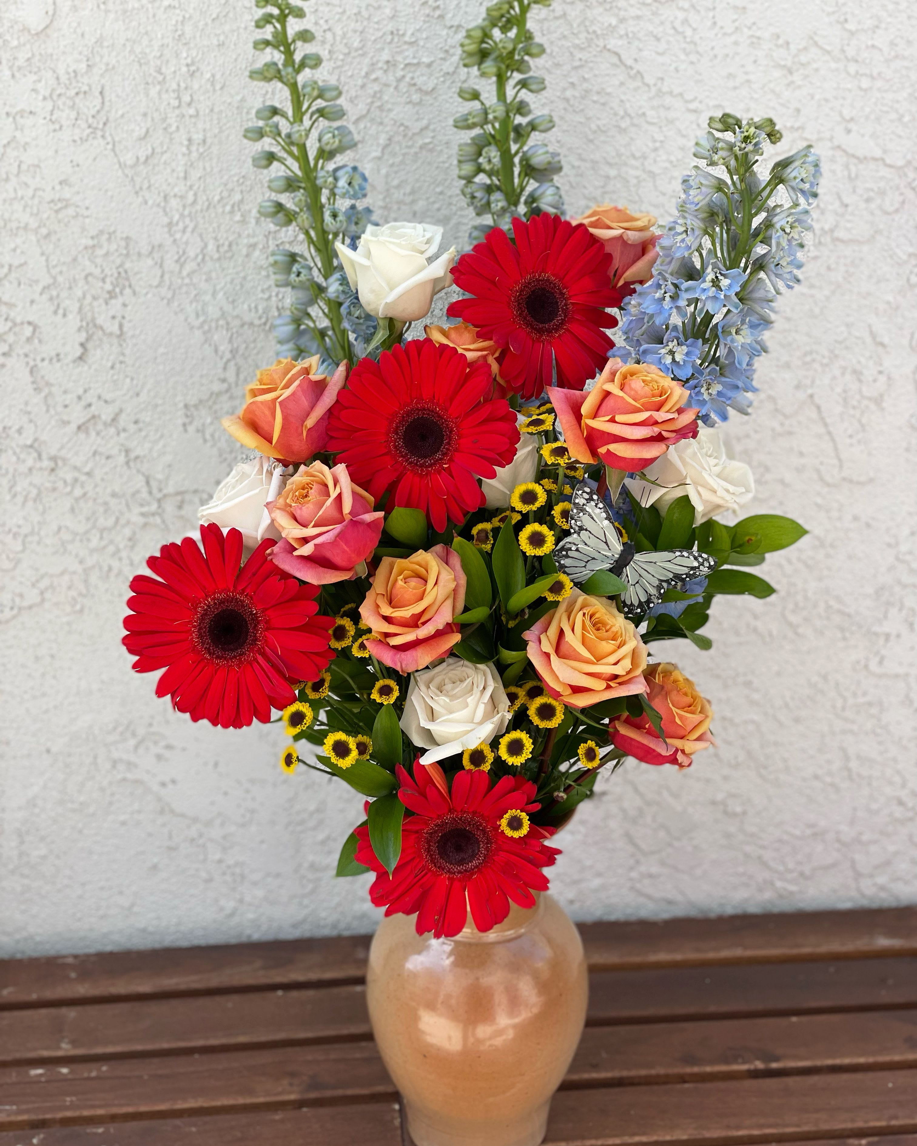 Marias blooms Marias blooms - Mixed colored roses and red daisies