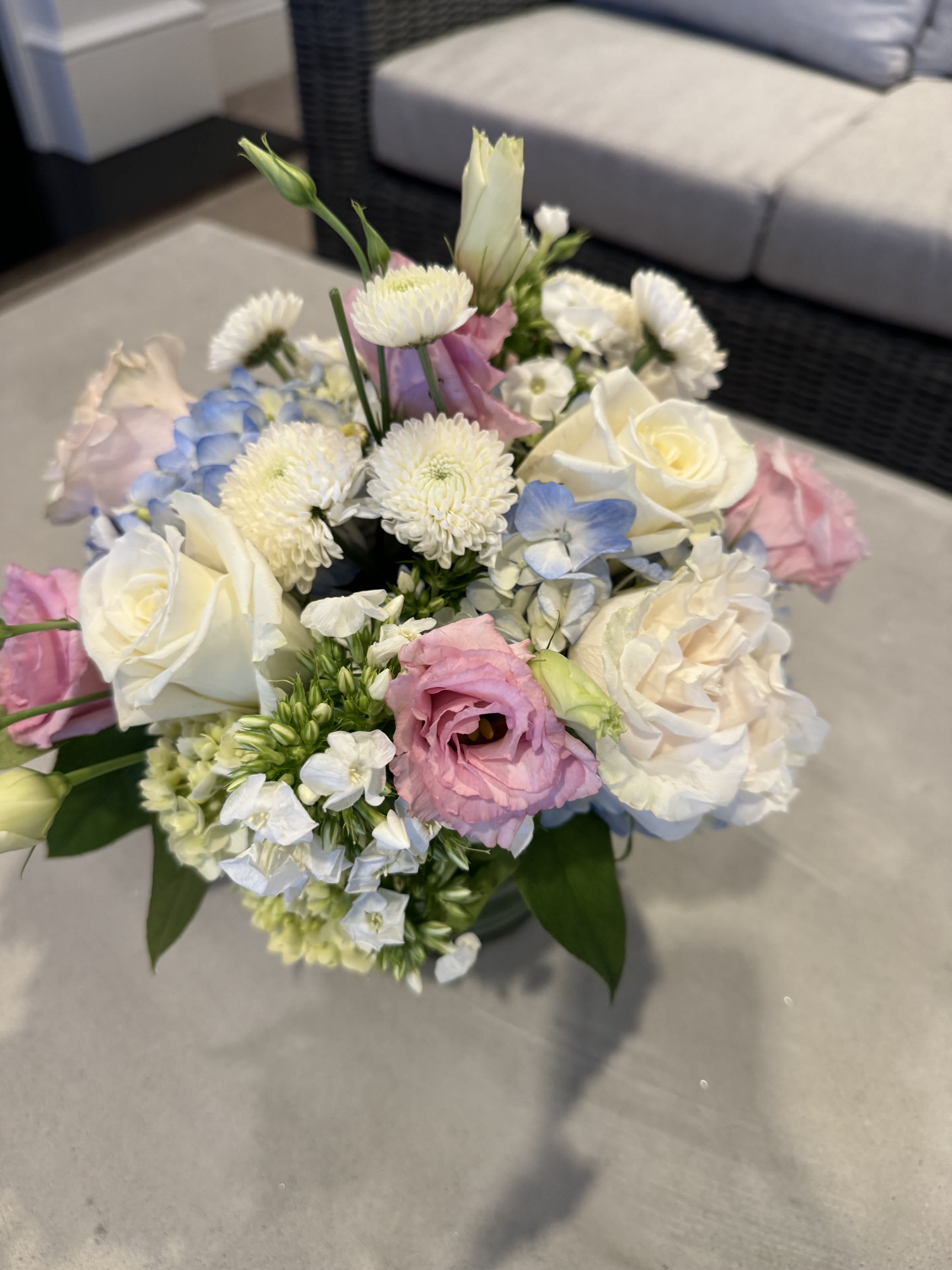 The Coastal Romantic  -  A perfect combination of coastal cool meets little sweet pinks.  We use blue hydrangea and pair it with pretty pink florals such as roses and lisianthus.  You may see some pink or blue locals mixed in.  Its a super soft look that is perfect for so many occasions!  This is a super popular palette for Mother's Day, baby showers, bridal showers, BFFs and is simply Westport chic!   Standard size is built in a 4x4 vessel  Deluxe size in a 6x6  Premium size in a large scale 8x8   All low &amp; lush.
