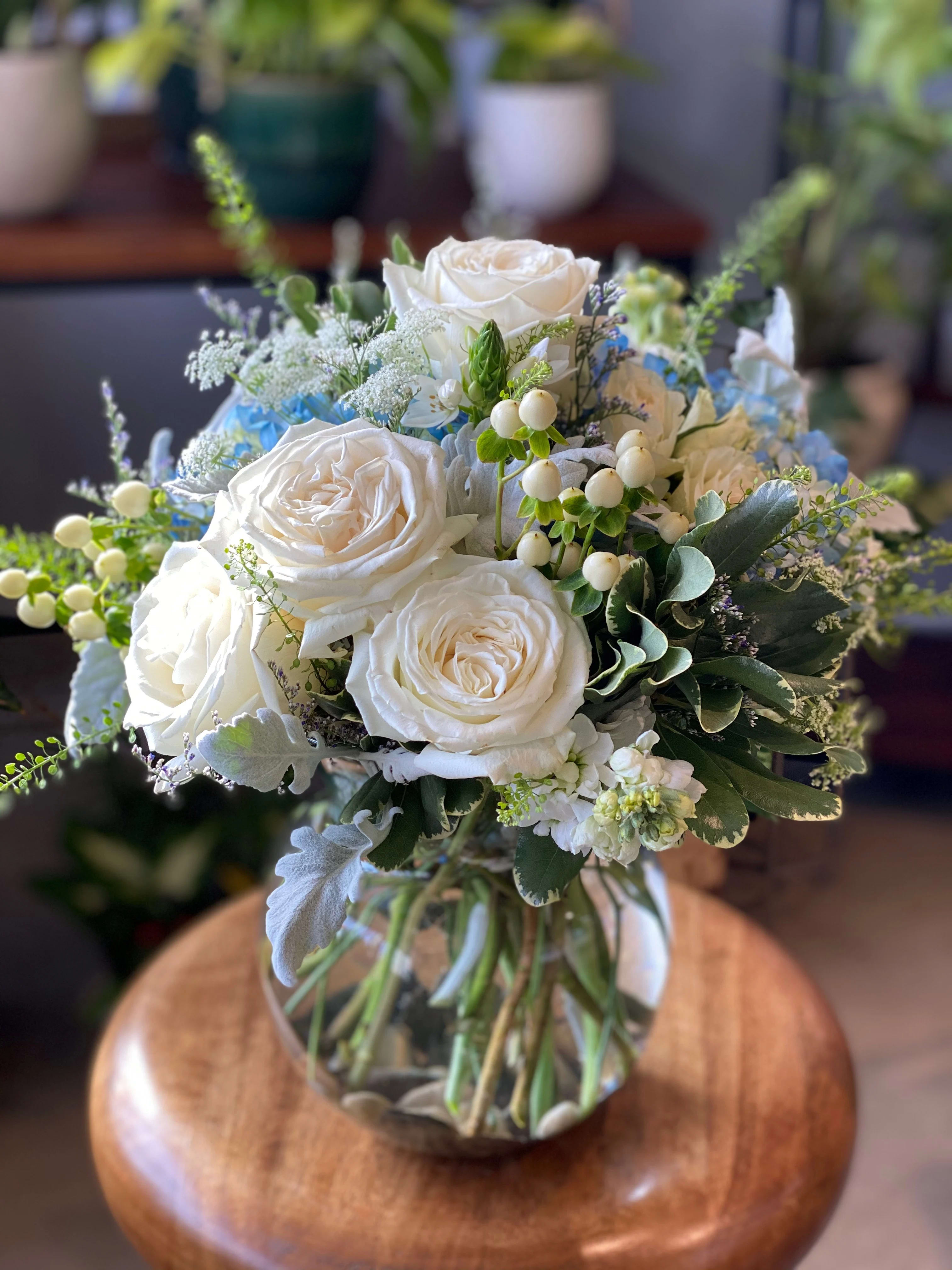 The Bailey by Simply Fresh Flowers - The Bailey is designed with premium blue hydrangea, white roses, stock, hypericum berry &amp; accent blooms.  An all sided design that's simply beautiful for any occasion!