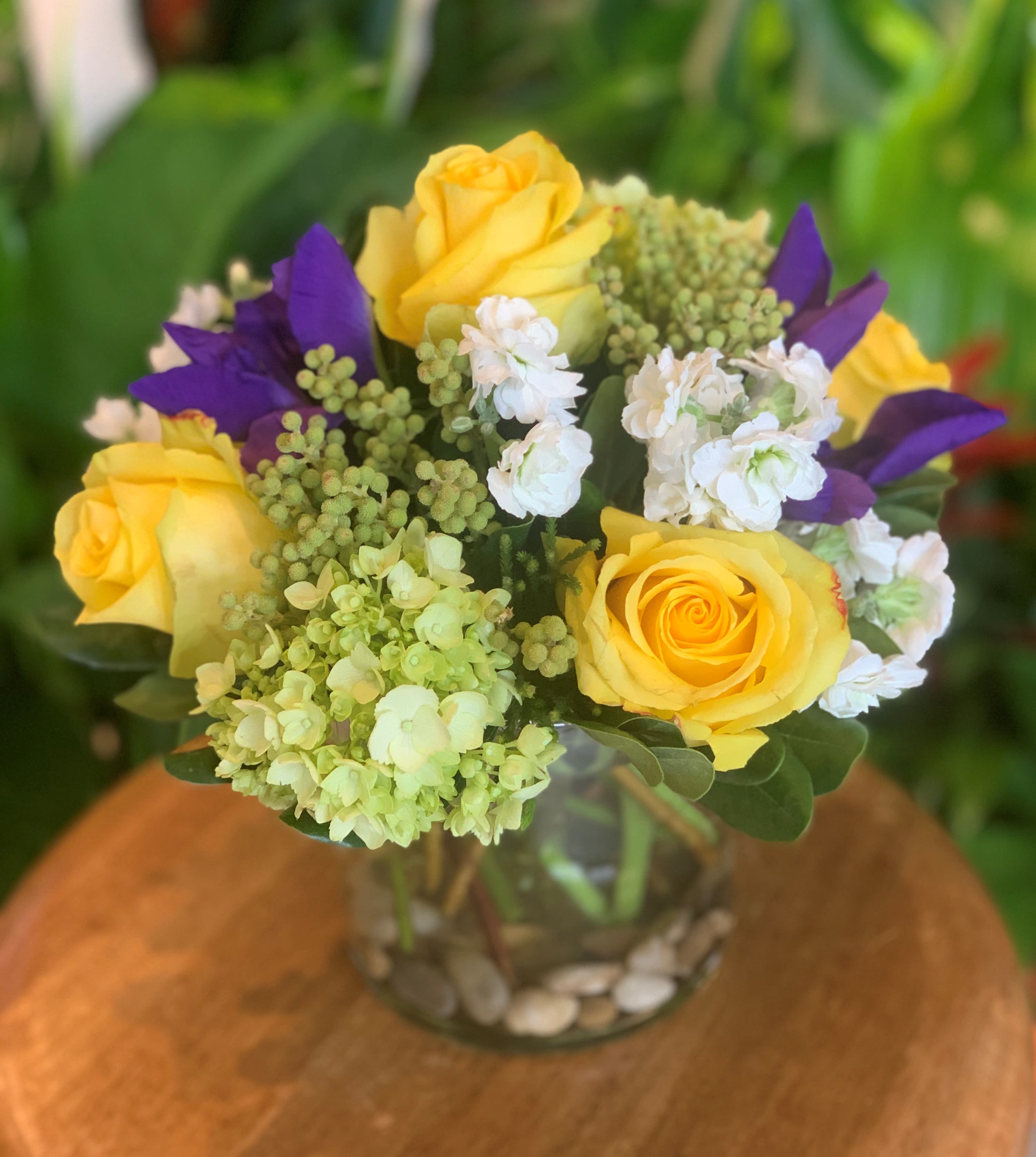 The Blayne by Simply Fresh Flowers - The Blayne incorporates yellow roses, purple iris, stock, mini hydrangea &amp; complementary accent blooms.