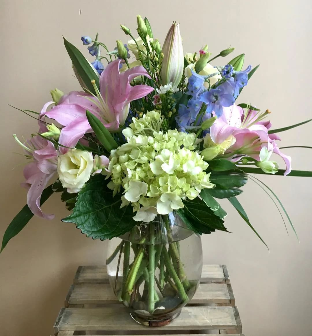 The Sadie by Simply Fresh Flowers - The Sadie is an all sided soft &amp; pastel design of premium blooms including pastel pink oriental lilies, blue delphinium, hydrangea &amp; lisianthus. Please note: this design is highly scented.