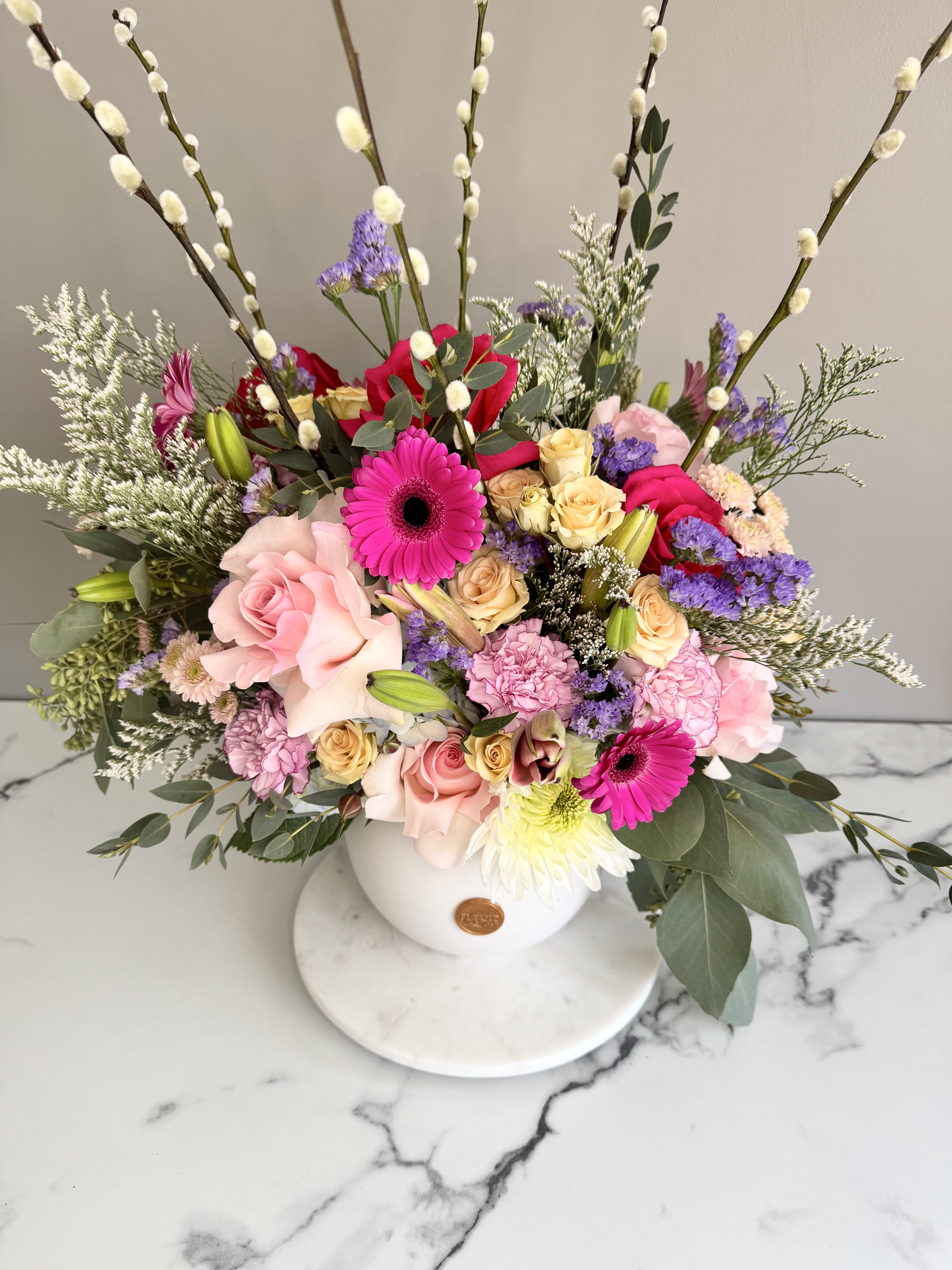 Spring Sonata - Celebrate the beauty of new beginnings with Spring Sonata—a stunning, large floral composition that harmonizes soft pastels with vibrant blooms. Accented by graceful flowering branches, this grand arrangement is perfect as a statement piece for a foyer or a spacious kitchen island. Whether as a thoughtful gift or a striking centerpiece, Spring Sonata brings elegance and the promise of fresh possibilities into any space.