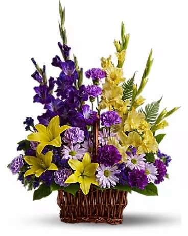 Basket of Memories- Purple and Yellow  - Regal purple and yellow blooms are a colorful tribute to a life well lived. This unique sympathy basket accents yellow lilies and purple gladioli with tropical greens and ferns. Beautiful flowers such as yellow asiatic lilies, yellow gladioli, dark purple gladioli, purple and lavender carnations, purple statice, lavender daisies, sword fern and salal. Delivered in a rectangular basket with handle. Orientation: One-Sided  SUBSTITUTION POLICY – Always deliver the freshest flowers! Please note the bouquet pictured reflects our original design.  If the exact flowers or container in this arrangement are not available, our local florists will create a beautiful bouquet with the freshest available flowers.