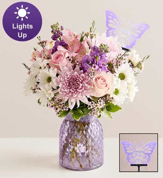 Amazing Mom with a butterfly Amazing Mom with a butterfly - An arrangement with pink roses, pink alstromeria, white daisies, purple stock, white daisies, pink football mum with some fillers and greens. Note: Vase is subjected to change if it is not available.