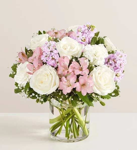 Elegant Blush Bouquet Elegant Blush Bouquet - An arrangement in a clear vase with white roses, pink alstromeria, lavender stock, white carnation along with some greens and fillers.