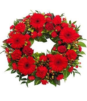 Classic Red Standing Wreath - Classic red round standing wreath is designed with red gerbera daisies, red rose, red spray roses and other red accent flowers with fresh greenery. 