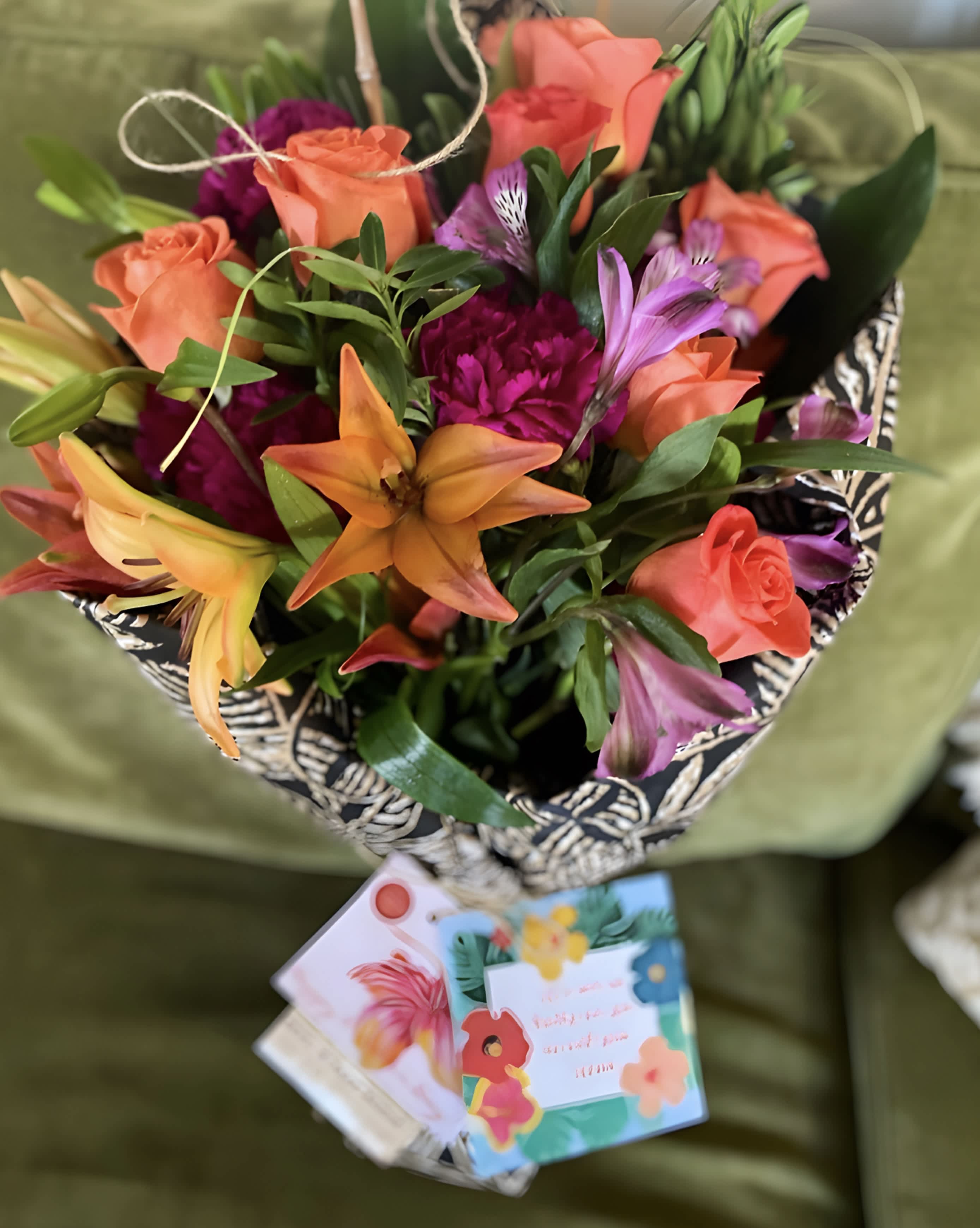 Designers Choice  - Rise and shine with this tall and bright arrangement. Tall reaching daisies, bells of Ireland and lilies in bright orange and green make this arrangement pop. Perfect for Cinco De Mayo, wishing somebody a happy birthday or welcoming a new baby.   APPROXIMATE DIMENSIONS 16&quot; W X 31&quot; H