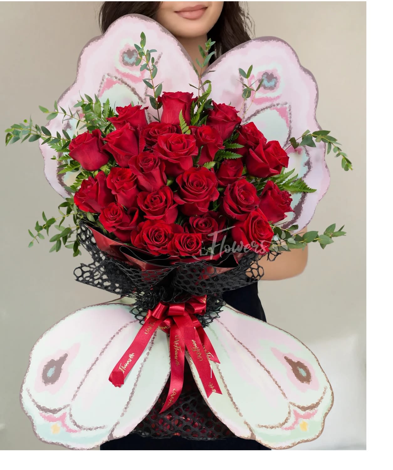 Fluttering Red Elegance Fluttering Red Elegance - This striking butterfly-shaped bouquet features 20 vibrant red roses, beautifully accented with lush green fillers. Tied with elegant ribbons, this arrangement exudes timeless beauty and romance, making it an ideal choice for special occasions or heartfelt gestures.