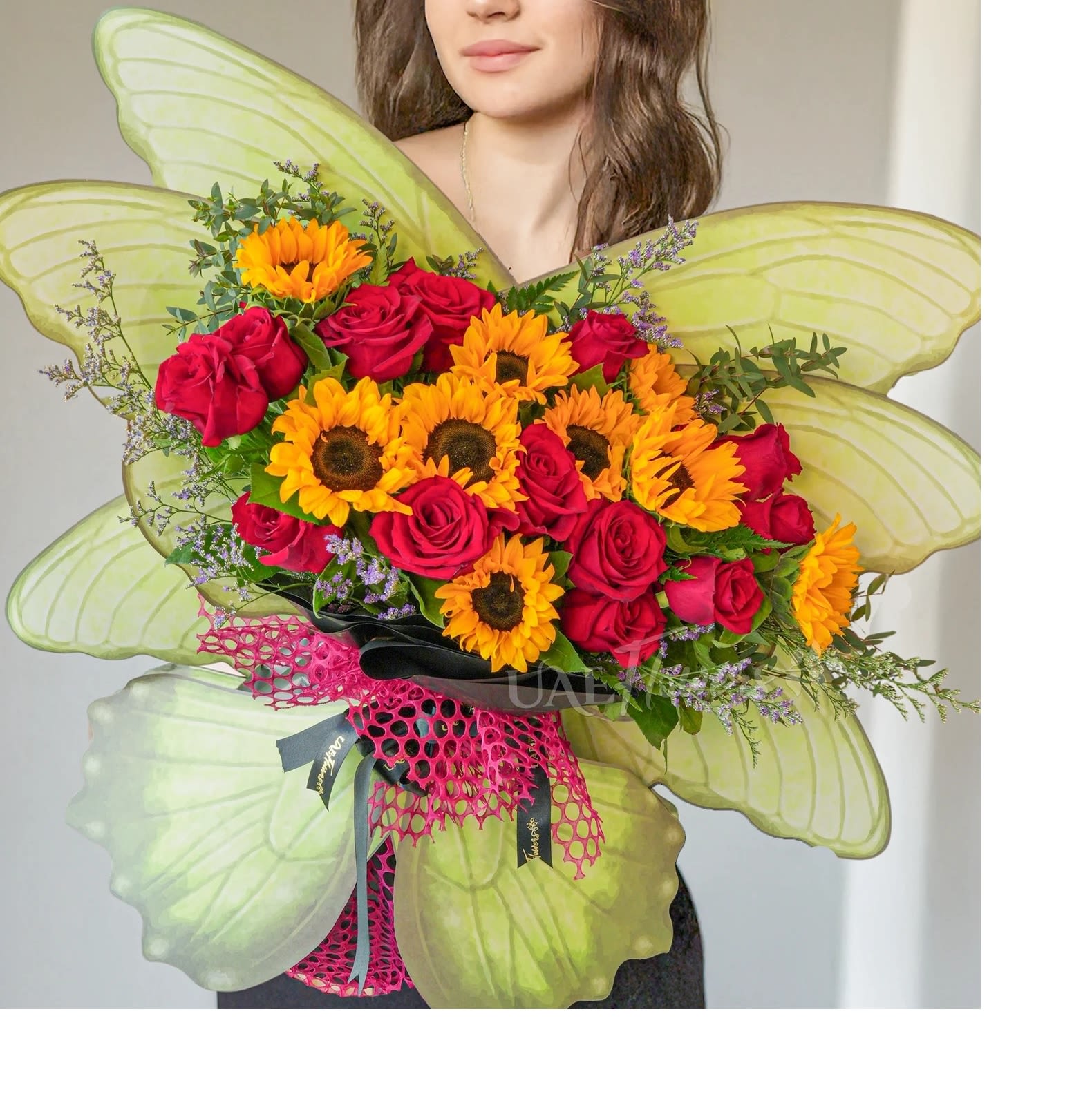 GOLDEN GLOW BUTTERFLY Bouquet GOLDEN GLOW BUTTERFLY Bouquet - This cheerful butterfly-shaped bouquet features a delightful blend of 12 sunflowers and 12 red roses. Accented with delicate limonium and lush green fillers, the bouquet brings together warm and lively tones, making it perfect for spreading joy and positivity.