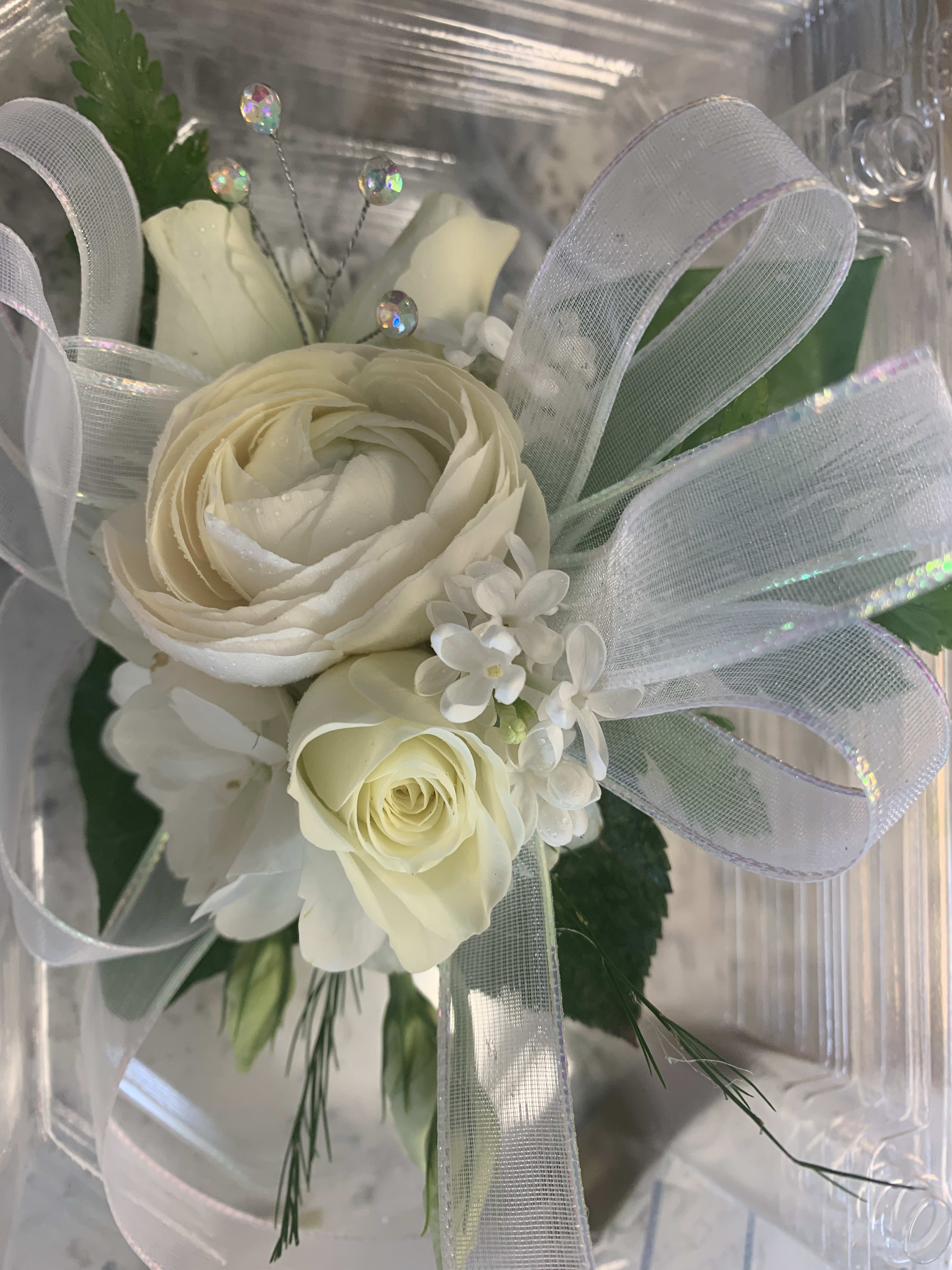 White Rose and Mixed Floral corsage White Rose and Mixed Floral corsage - A classic white corsage with silver or gold sheer ribbon. This wrist arrangement looks good with any outfit. Perfect for prom. Specify standard elastic bracelet or upgrade to gem or pearl stretch bracelet.