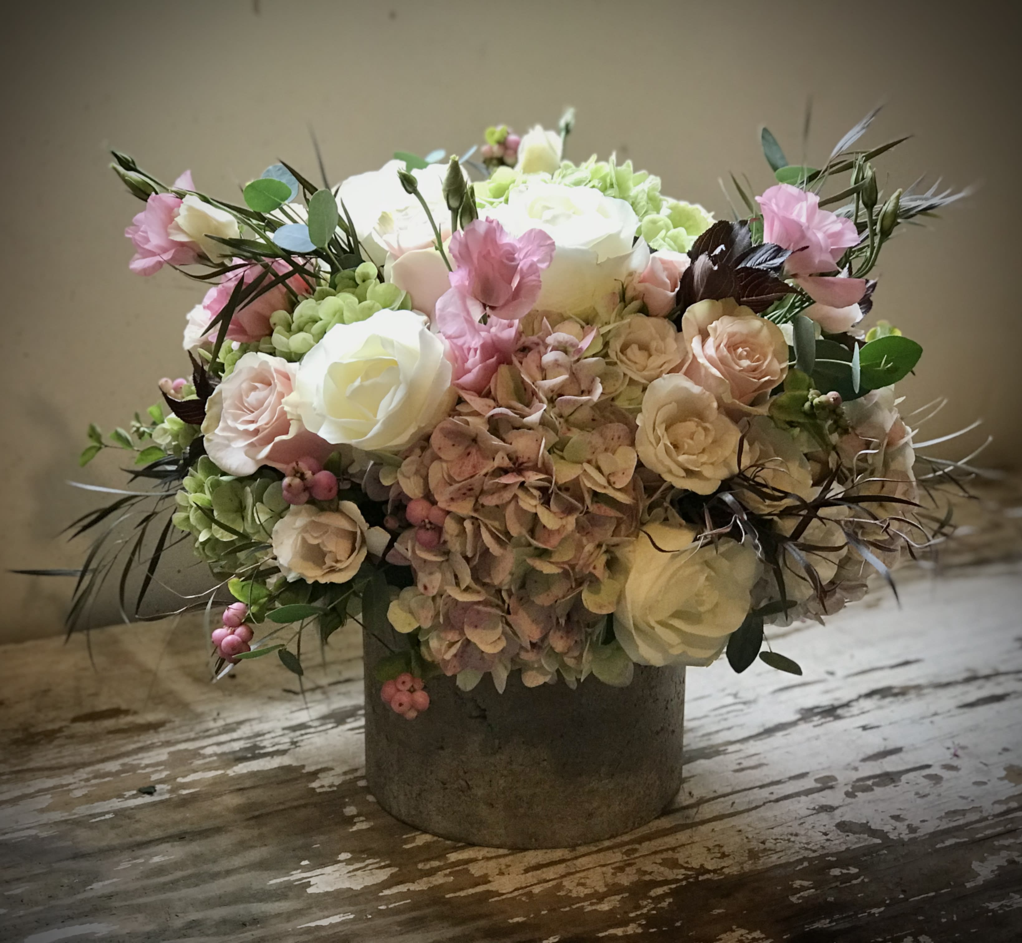 Isn’t it Romantic Isn’t it Romantic - Pinks, blush, and cream tones are gathered in an oversized rose gold cement container to create a large, lush romantic arrangement.