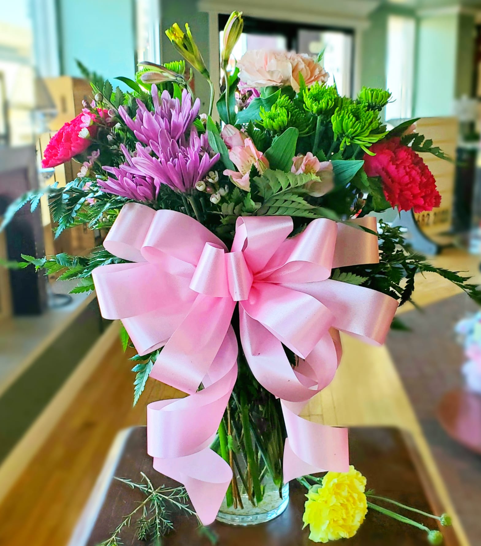 Daisies All Around - A beautiful colorful mix of flowers that would do nicely for any occasion.  Wrapped nicely with a bow, this arrangement comes with a colorful variety of carnations, alstromeria, and daisies.   Colors may vary. Approx 18 inches tall by 12 inches wide